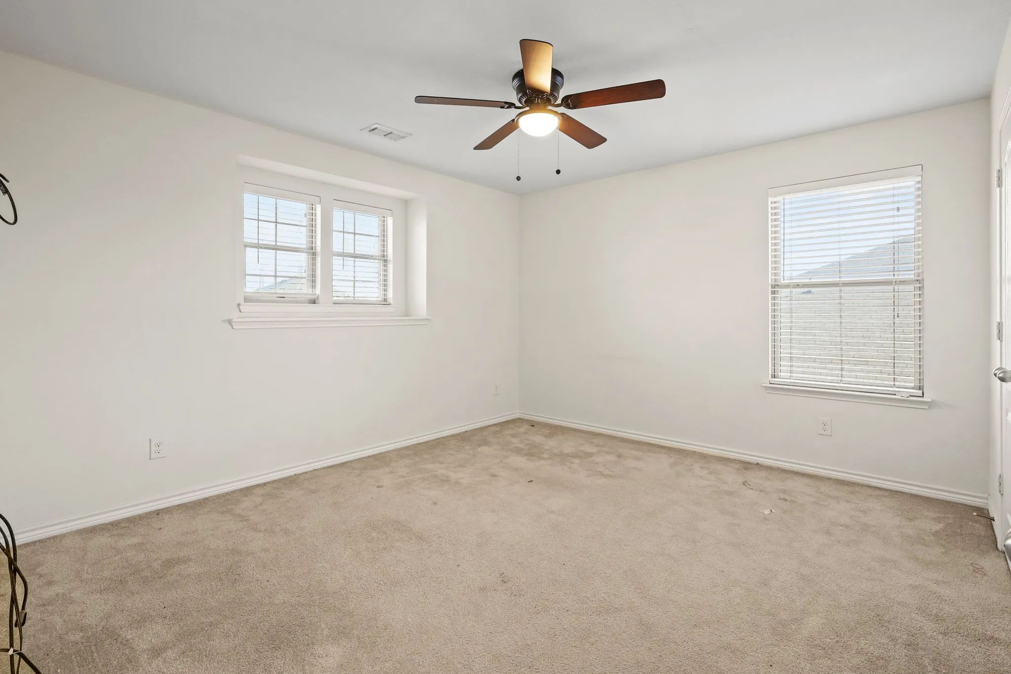 Spare room featuring plenty of natural light and light colored carpet