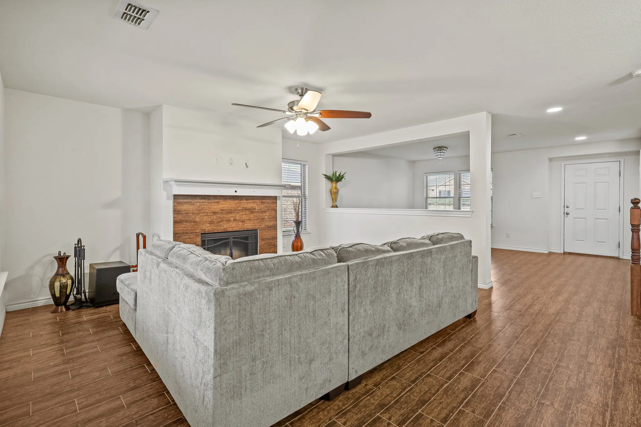 Living room featuring a wealth of natural light, ceiling fan, and dark wood-type flooring