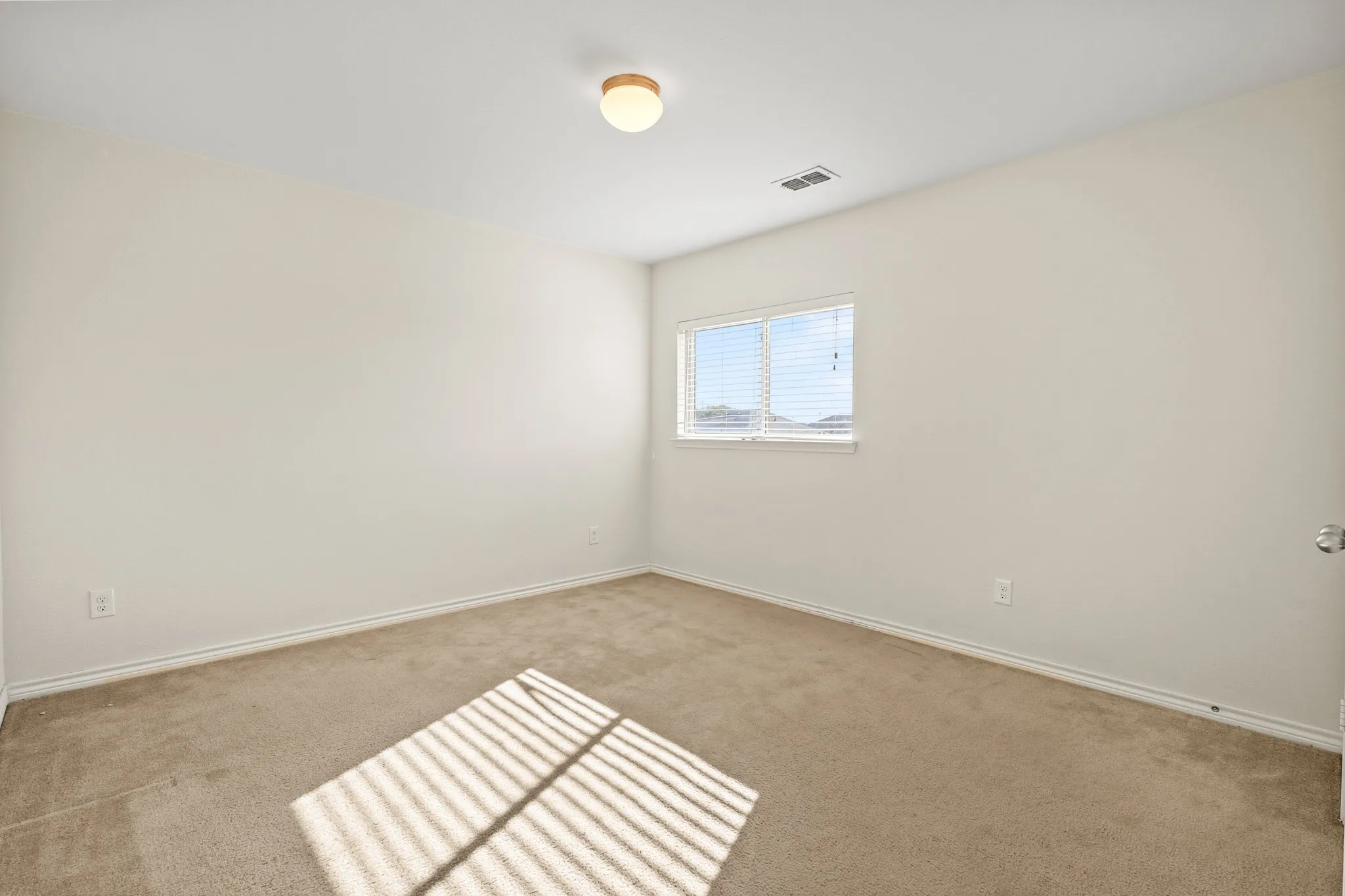 Empty room featuring light colored carpet