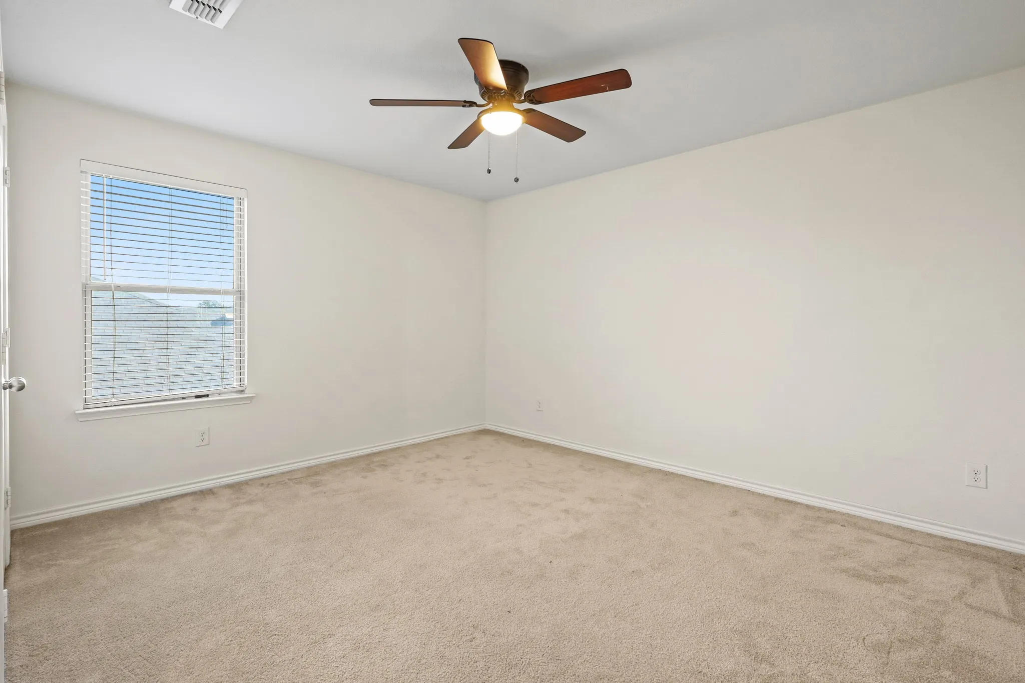 Empty room featuring ceiling fan and light colored carpet