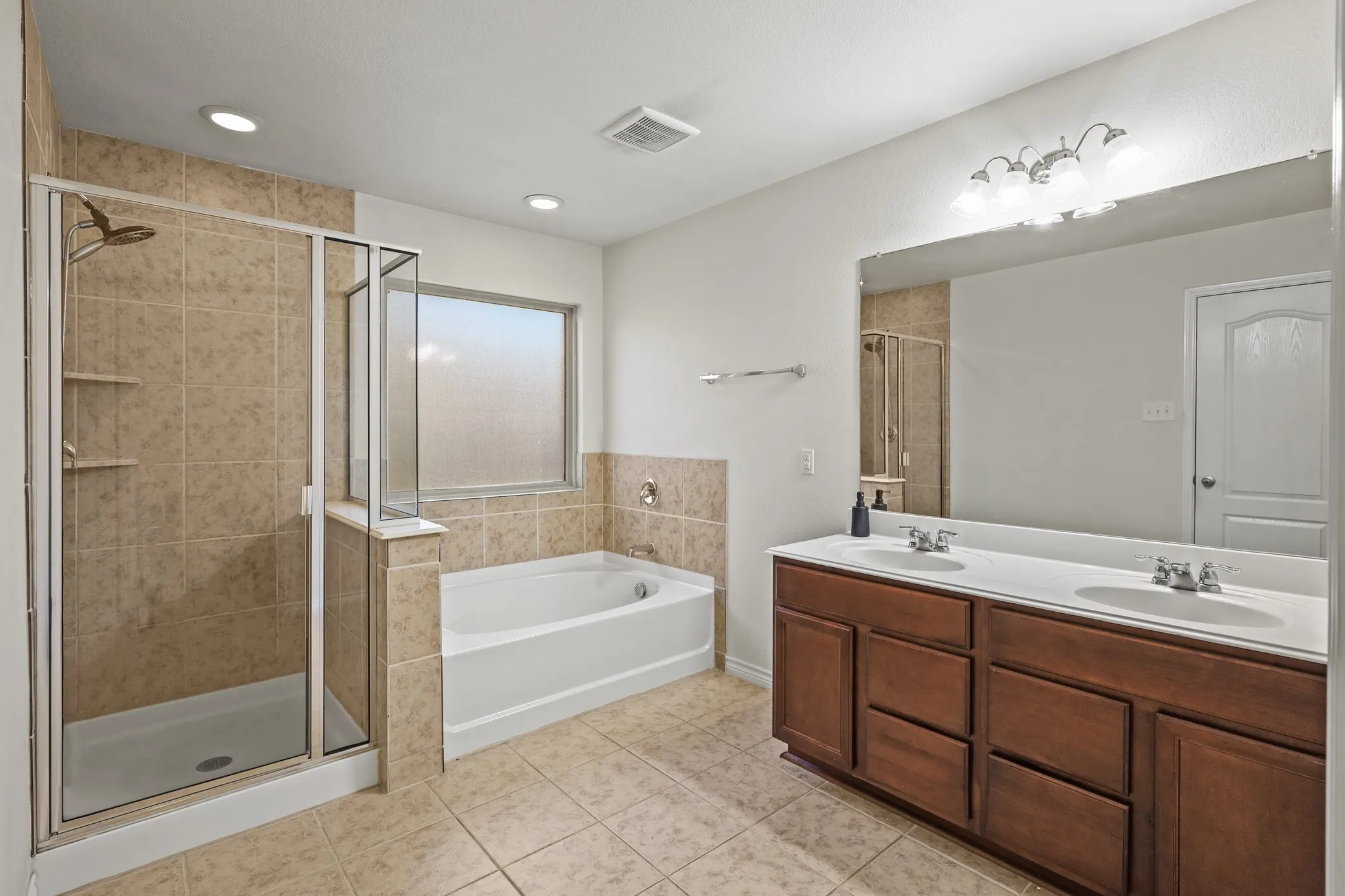 Bathroom with tile patterned floors, vanity, and plus walk in shower