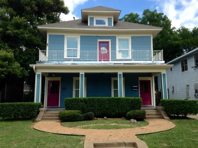 View of front of home with a balcony and a front lawn
