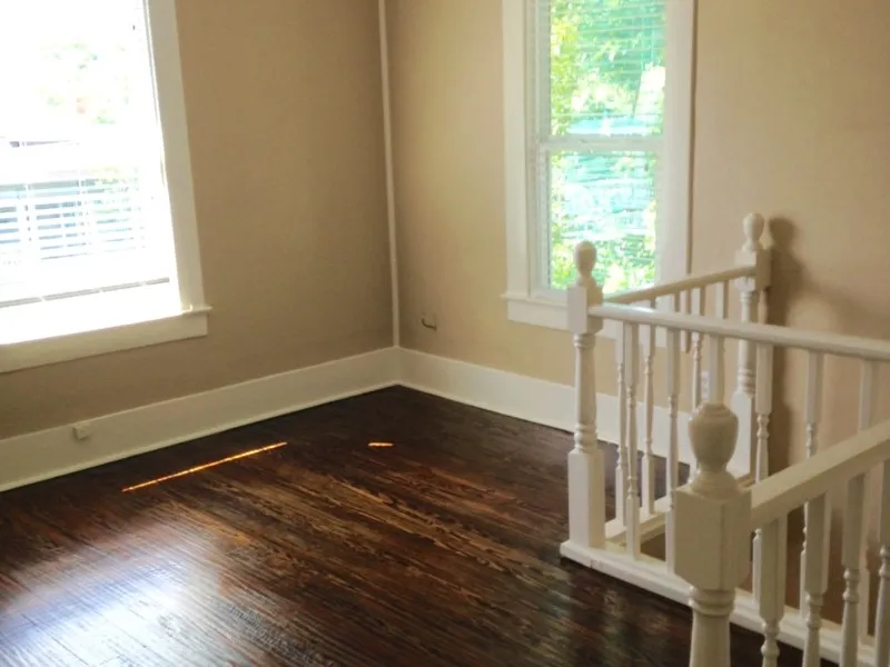 Spare room with a wealth of natural light and dark wood-type flooring