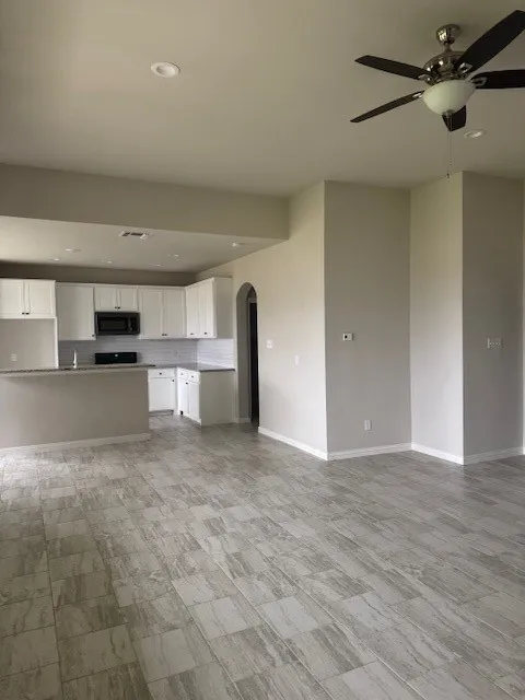 Unfurnished living room with ceiling fan