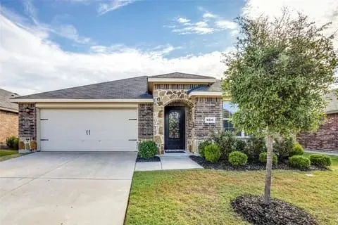 View of front of house with a front lawn and a garage