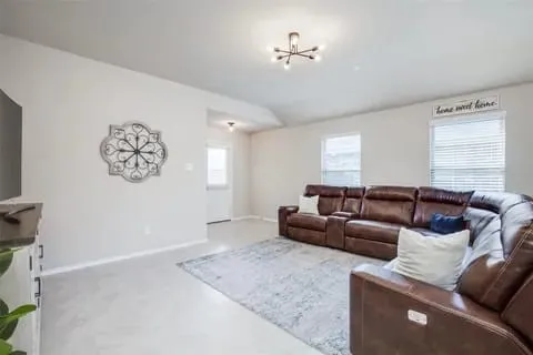 Living room featuring carpet, a healthy amount of sunlight, and an inviting chandelier
