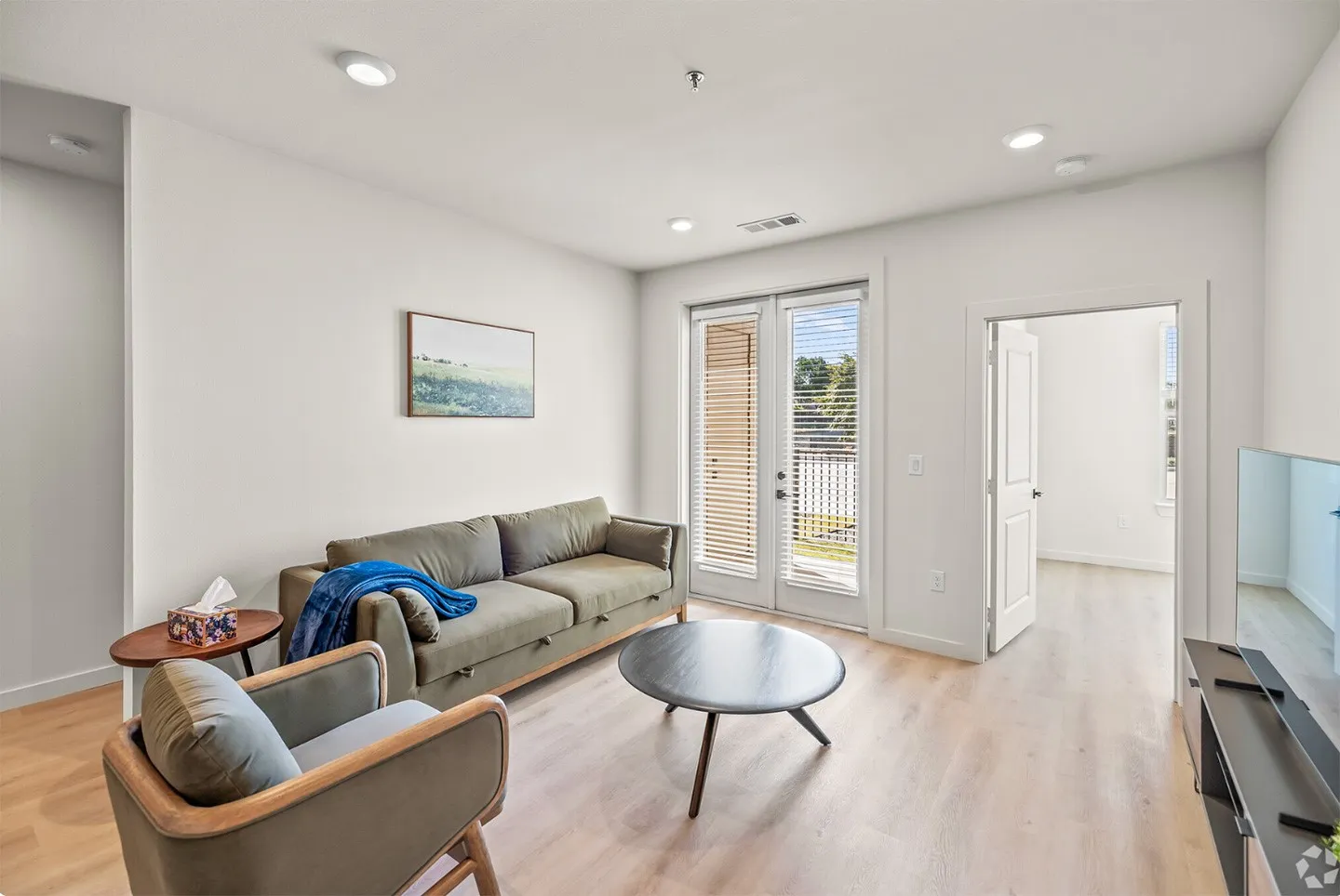 Living room with french doors and light hardwood / wood-style flooring