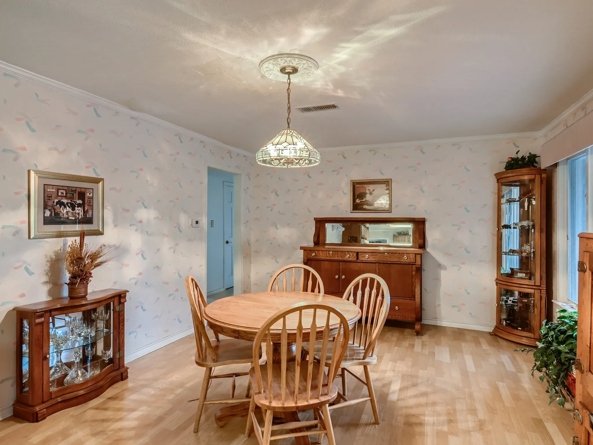 Dining space with a chandelier, light hardwood / wood-style floors, and crown molding