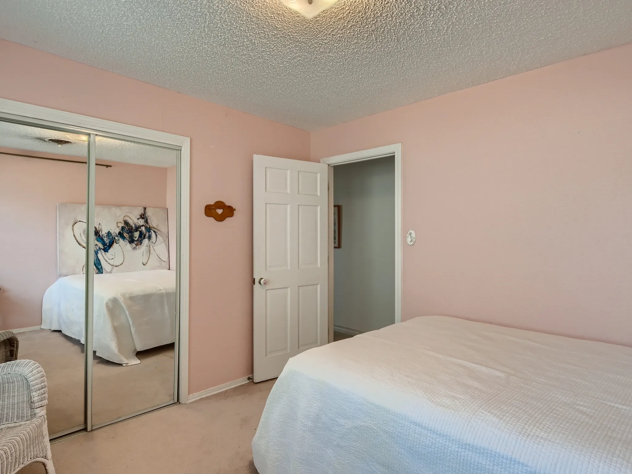 Bedroom featuring light carpet, a closet, and a textured ceiling
