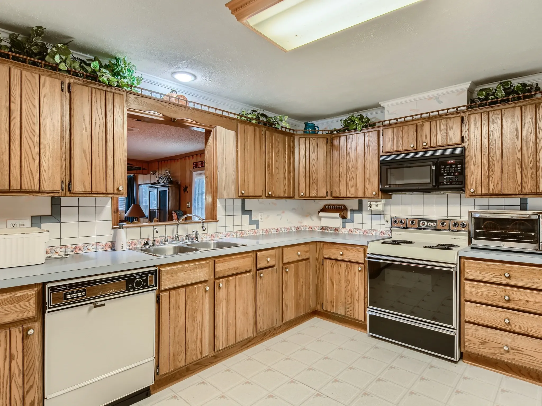 Kitchen with backsplash, white dishwasher, electric stove, sink, and a textured ceiling