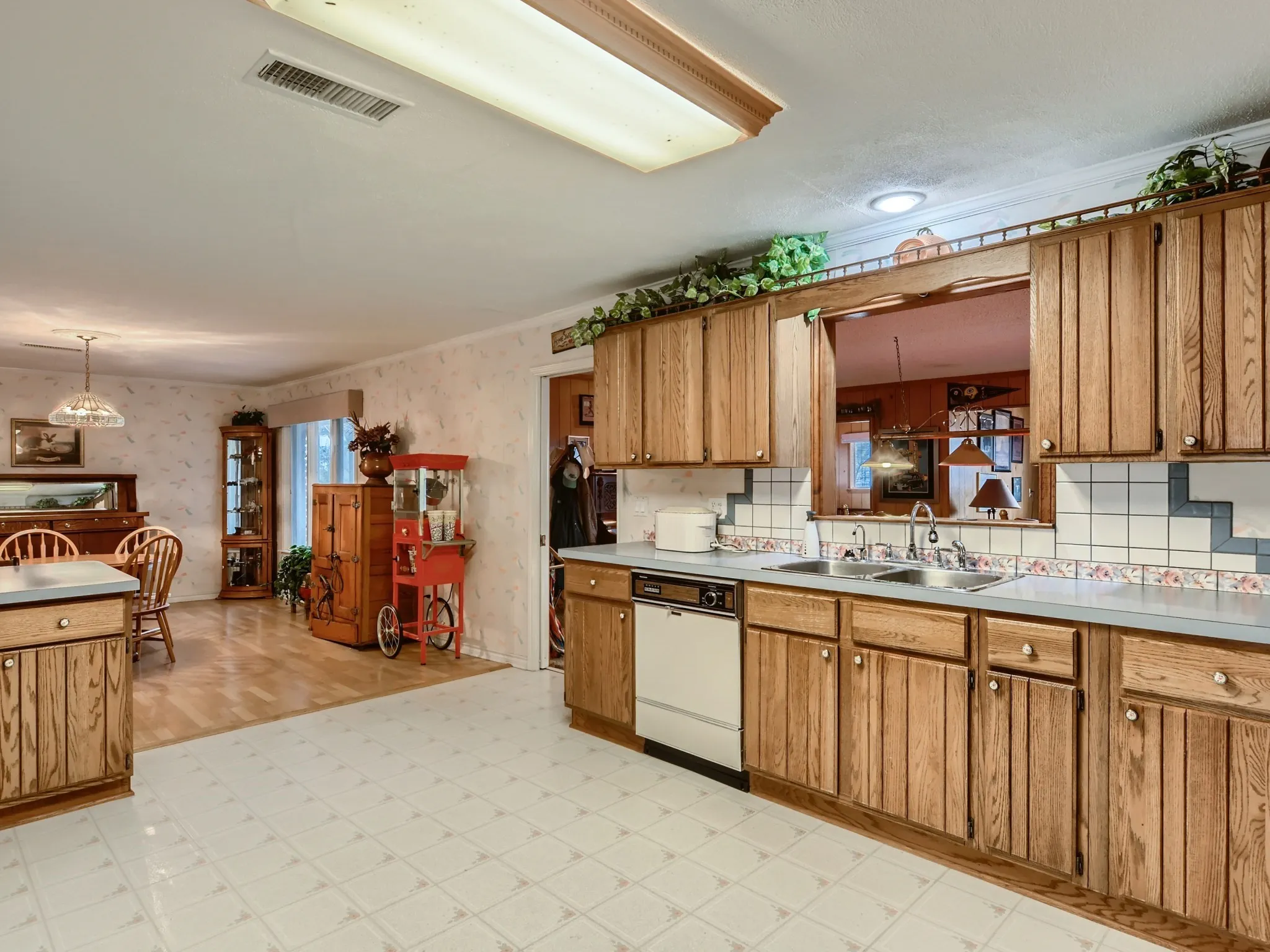 Kitchen with ornamental molding, dishwasher, pendant lighting, and sink