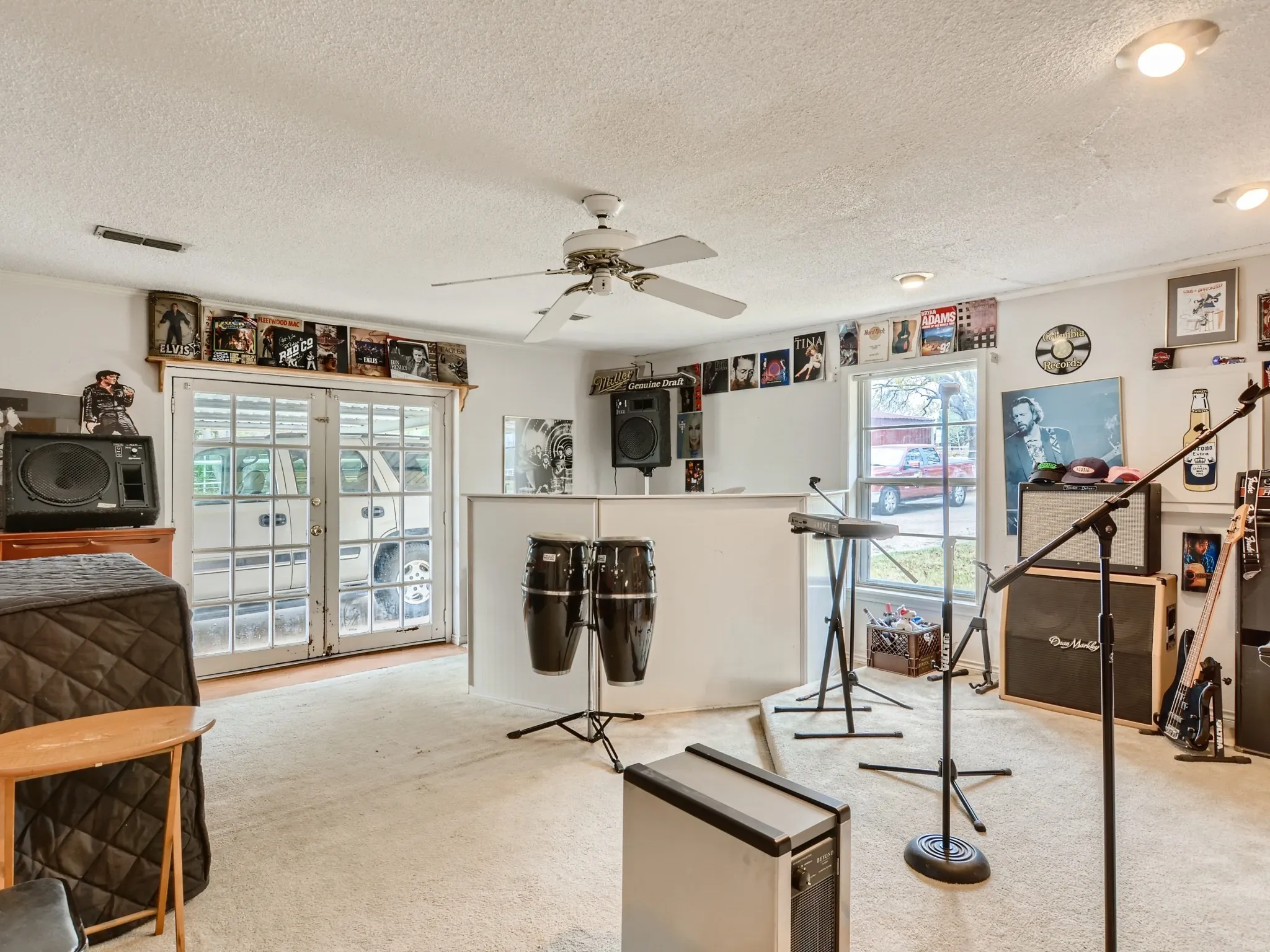 Living room featuring ceiling fan, light colored carpet, a textured ceiling, and french doors