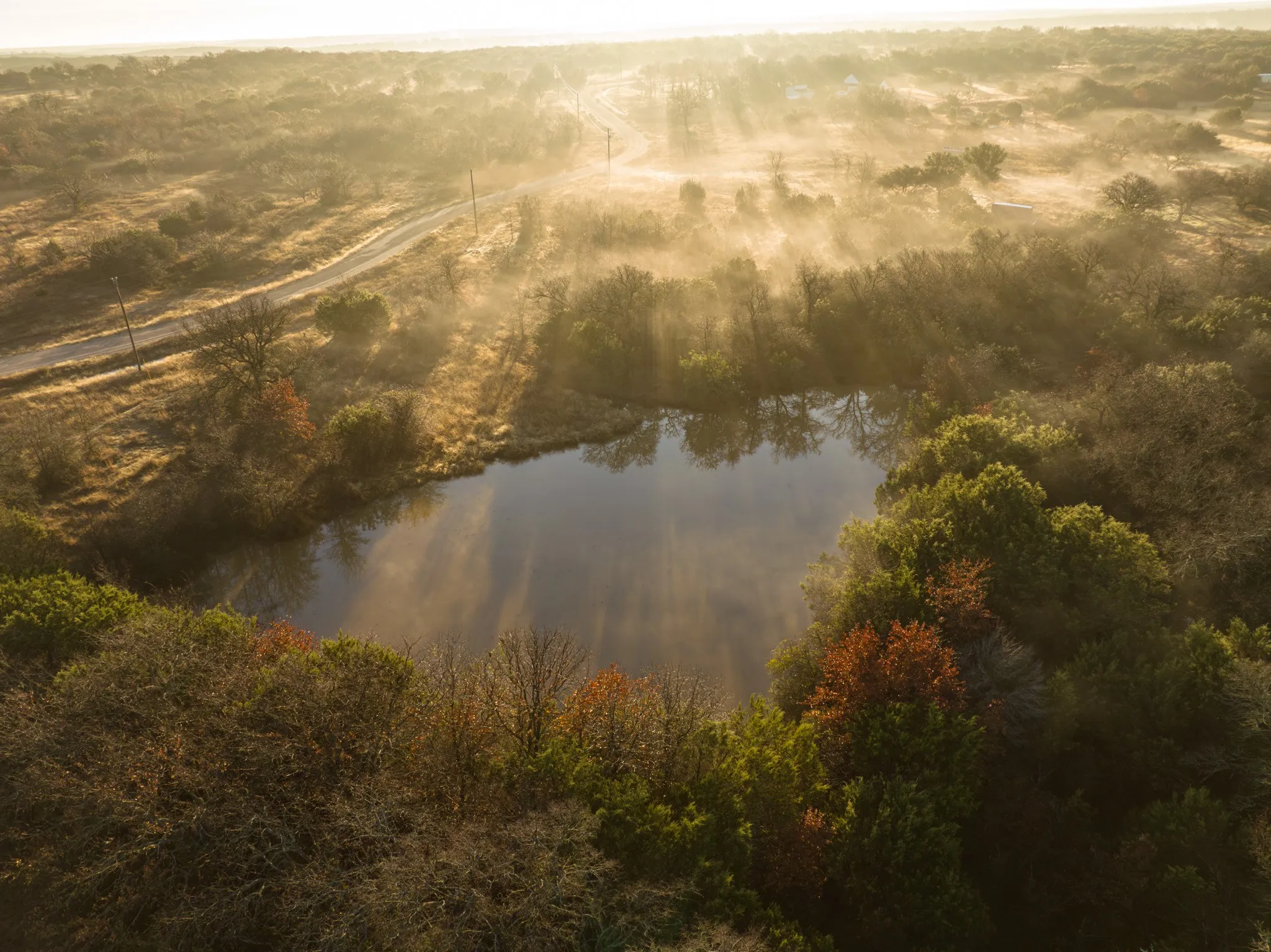 Birds eye view of property featuring a water view and a rural view