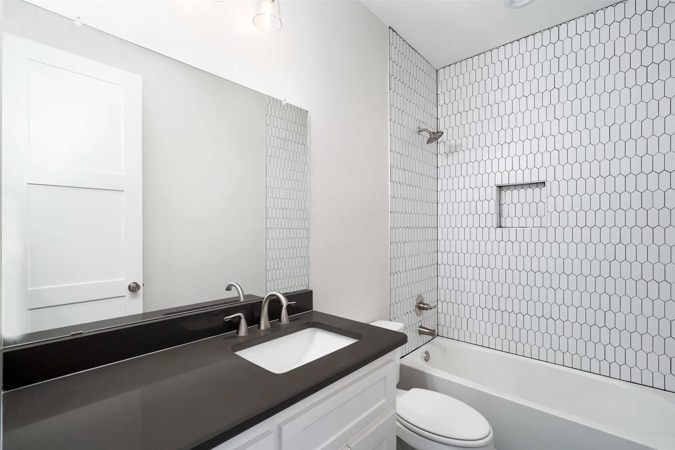 Full bathroom with vanity, tiled shower / bath combo, and toilet