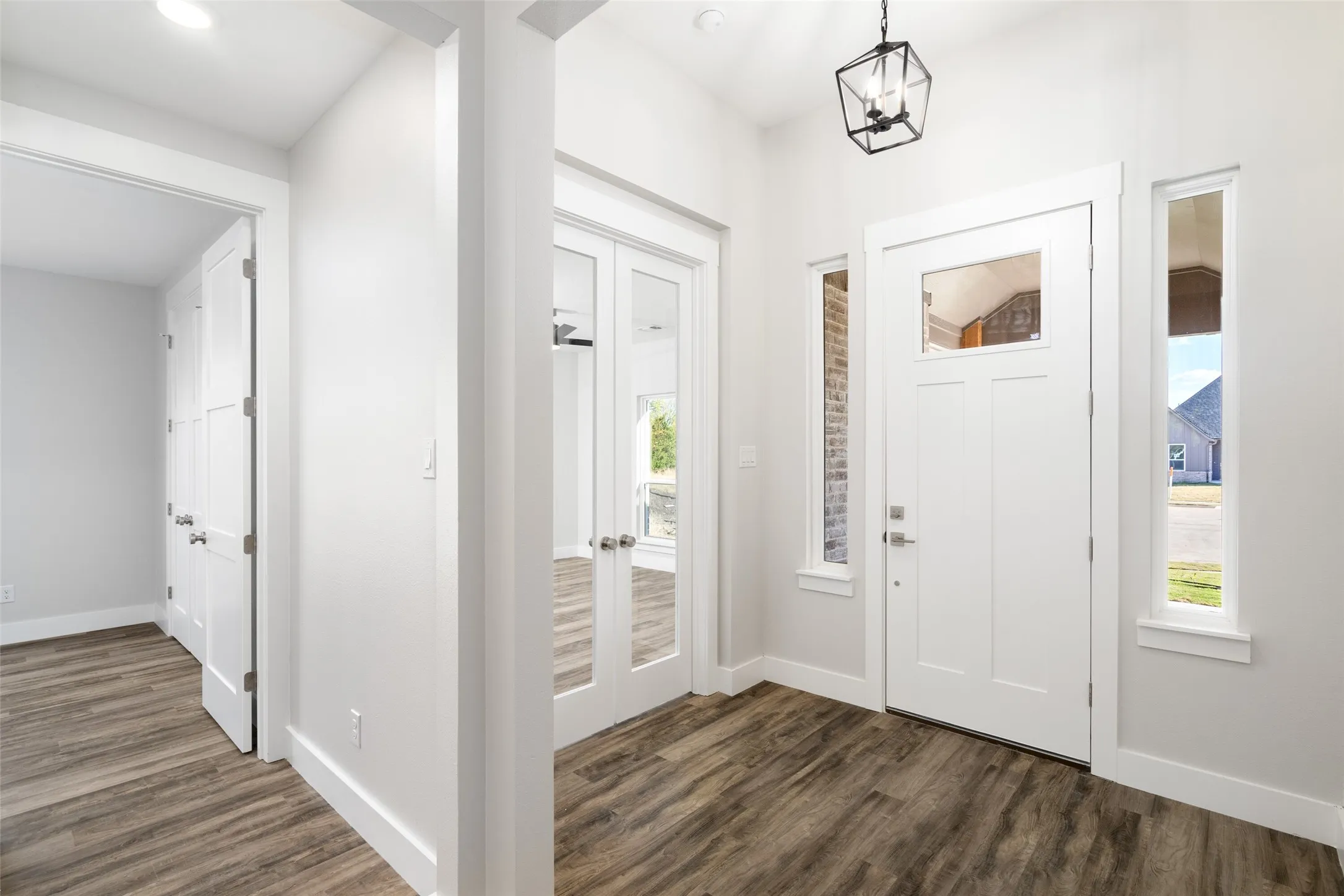 Entrance foyer with dark hardwood / wood-style flooring and a notable chandelier