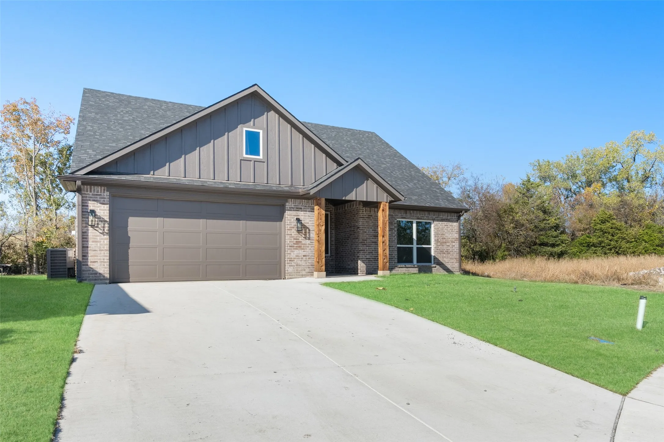 View of front of home featuring a front yard, a garage, and central air condition unit