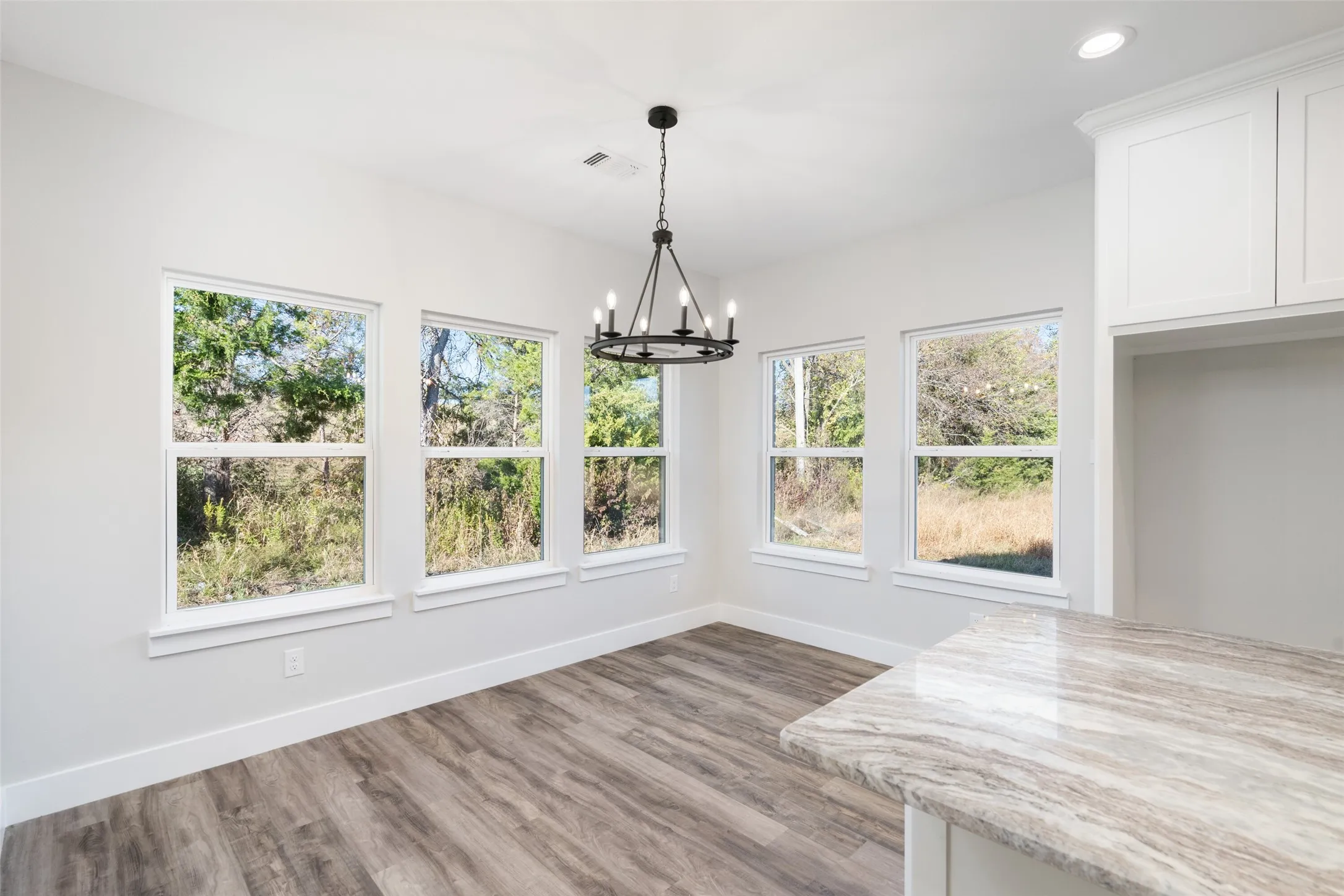 Unfurnished dining area featuring hardwood / wood-style flooring and an inviting chandelier