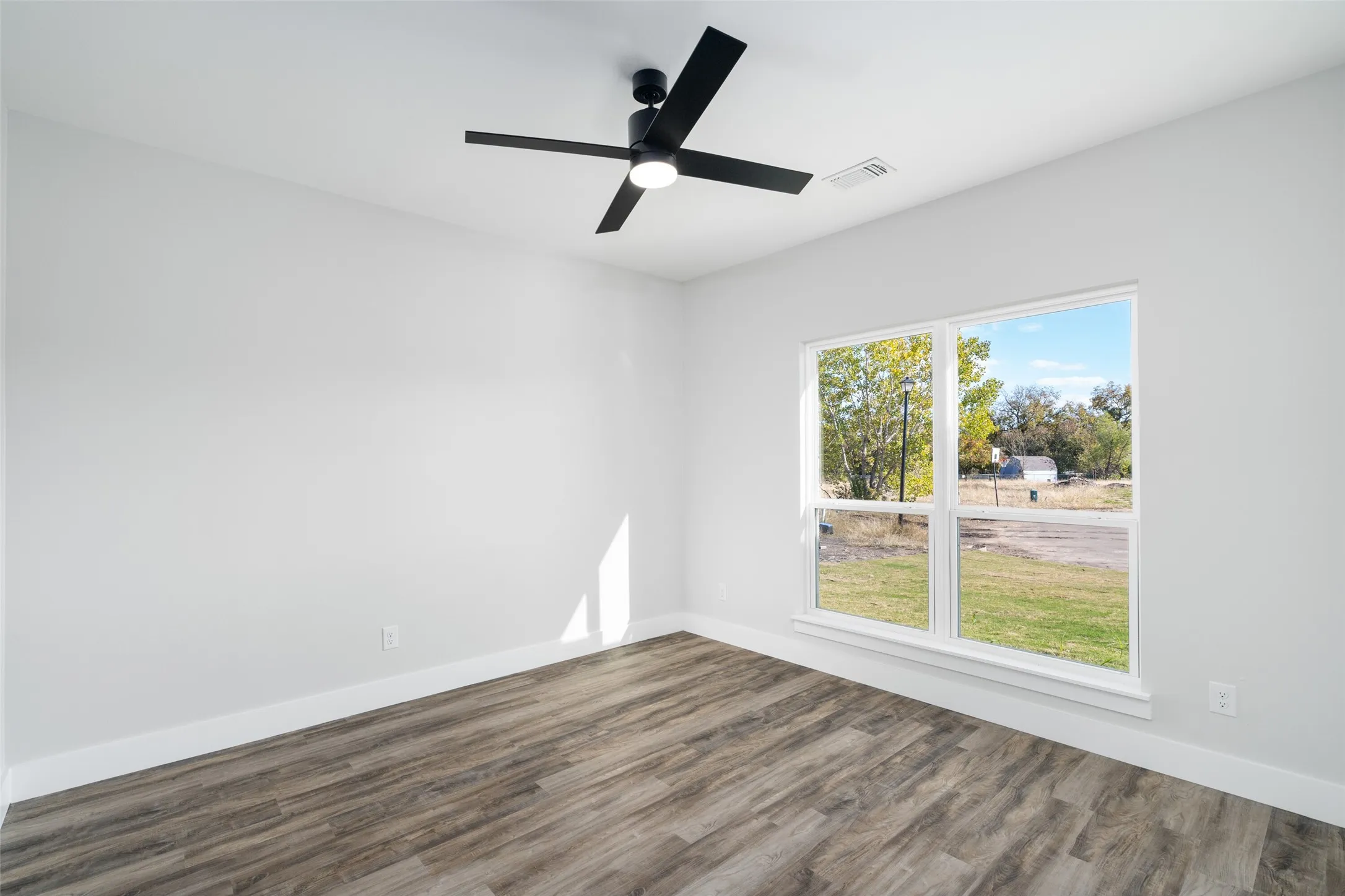 Unfurnished room with ceiling fan and dark hardwood / wood-style flooring