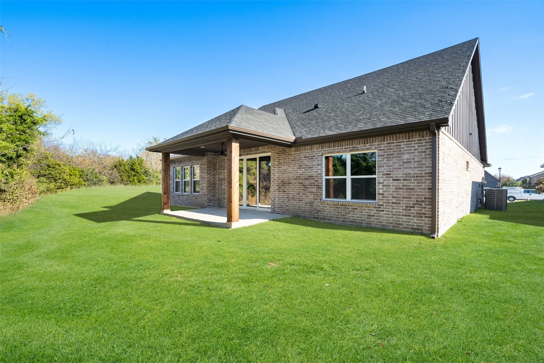 Back of property with a lawn, cooling unit, and a patio