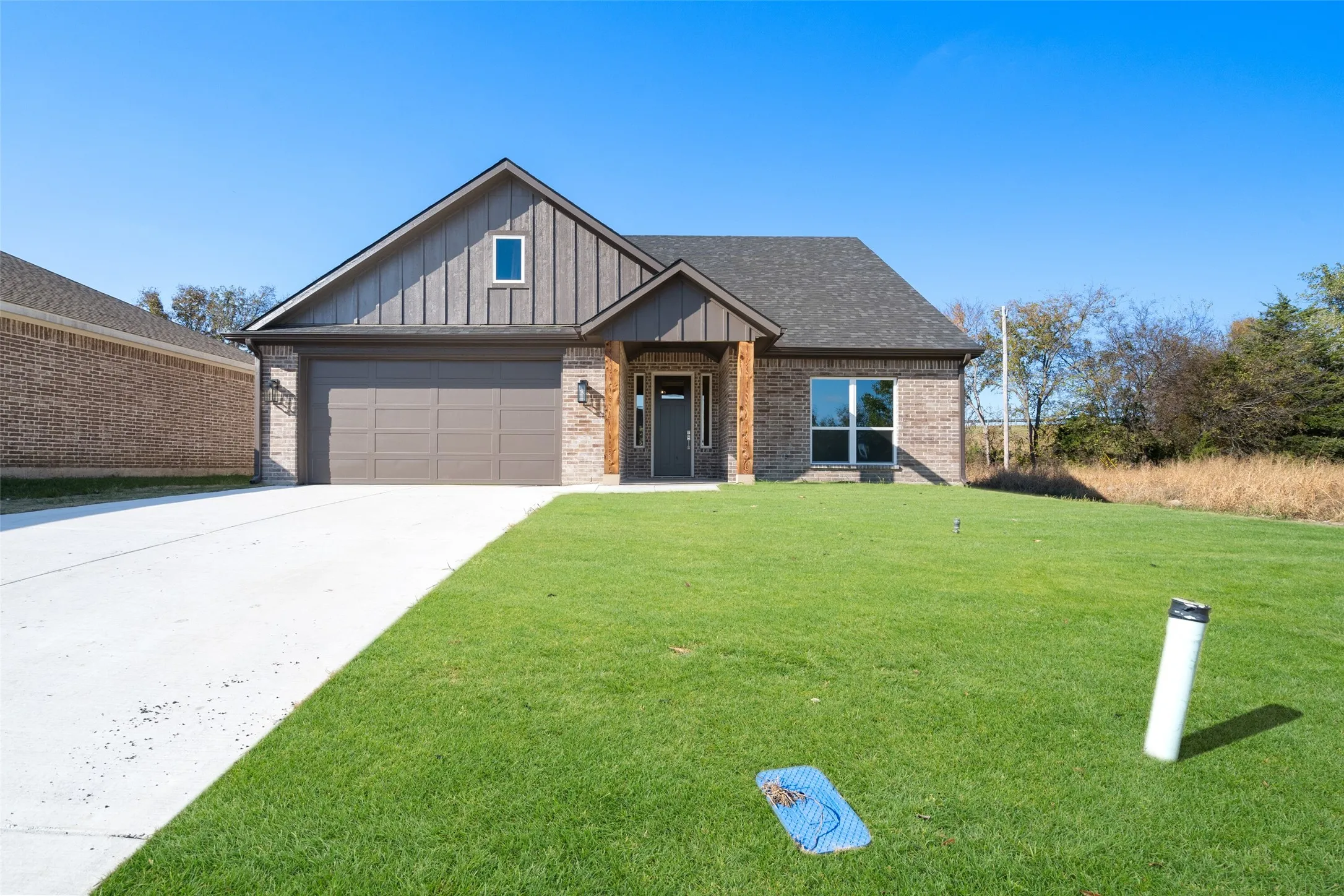 Craftsman-style house featuring a garage and a front lawn