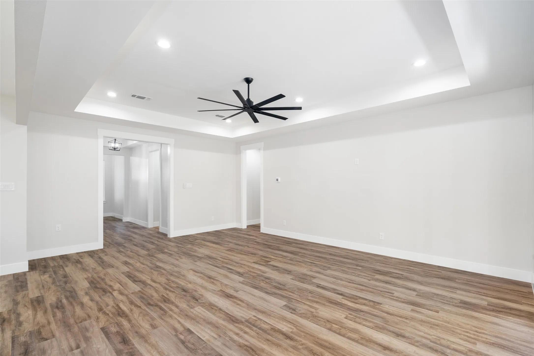 Spare room featuring hardwood / wood-style flooring, a raised ceiling, and ceiling fan