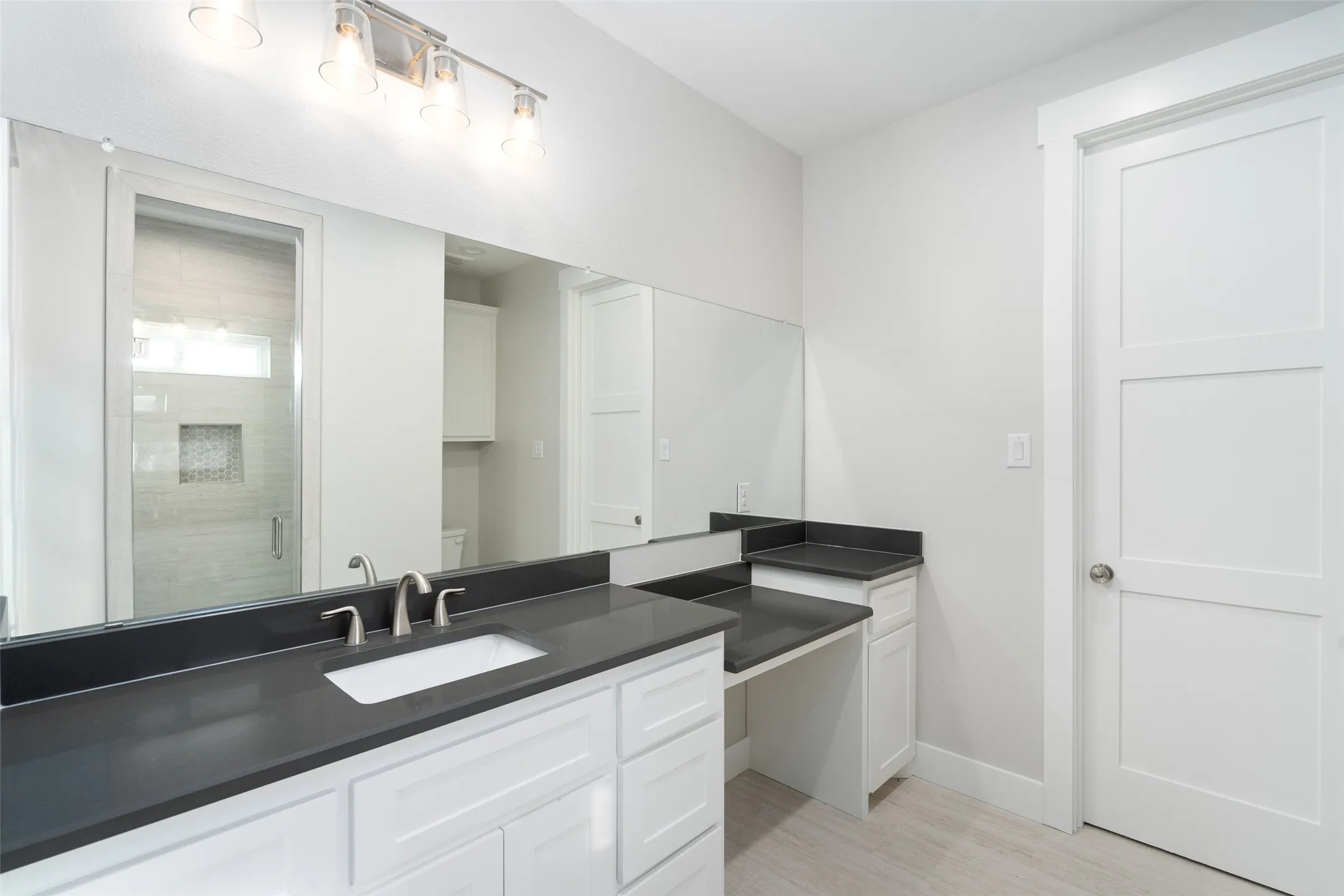 Bathroom with hardwood / wood-style flooring, vanity, an enclosed shower, and toilet