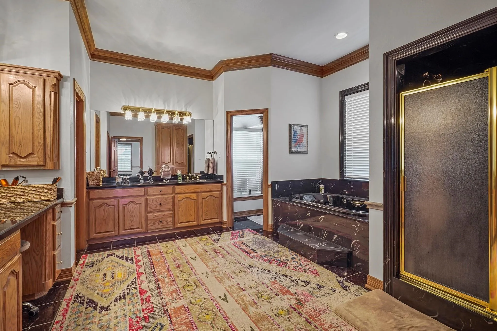 Bathroom with tile patterned floors, vanity, ornamental molding, and shower with separate bathtub