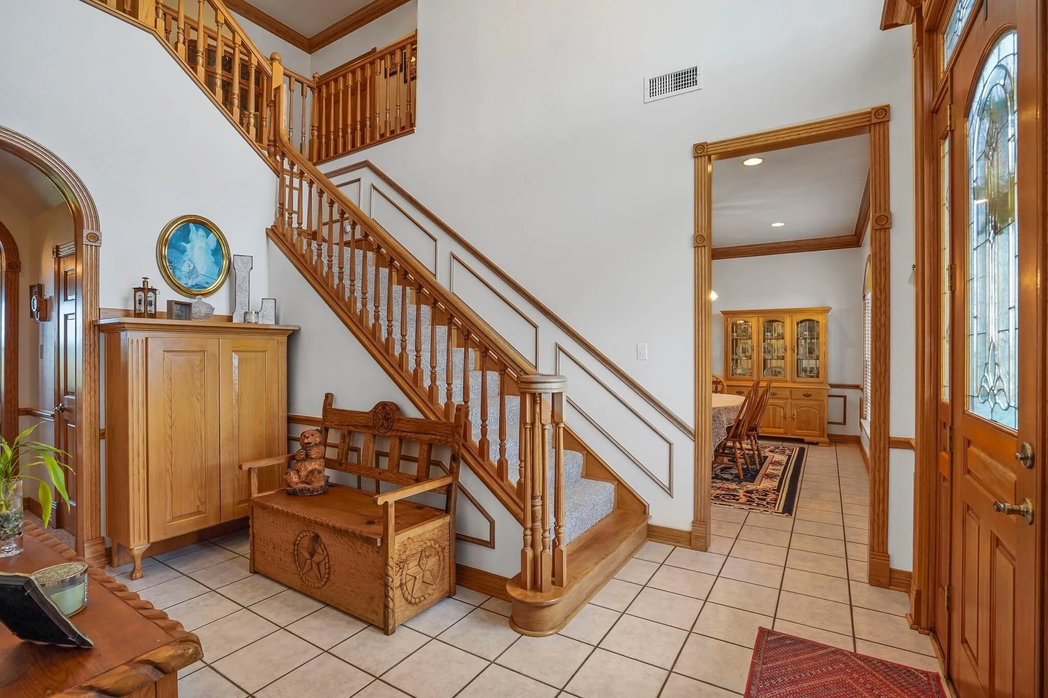 Foyer with a towering ceiling, crown molding, and light tile patterned floors