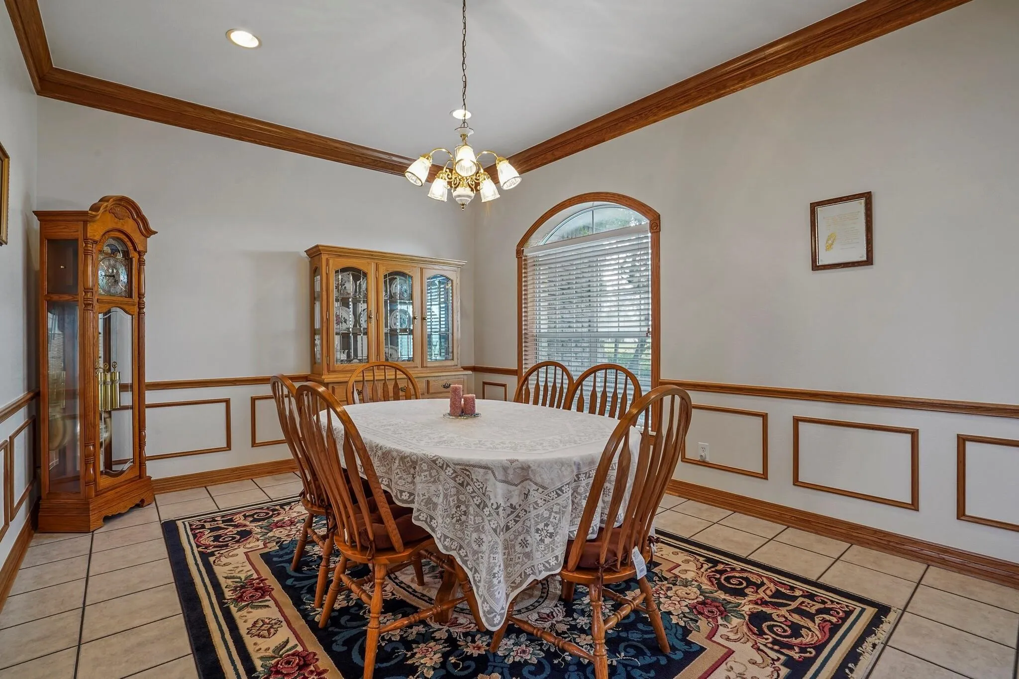 Dining space with a notable chandelier, light tile patterned floors, and ornamental molding
