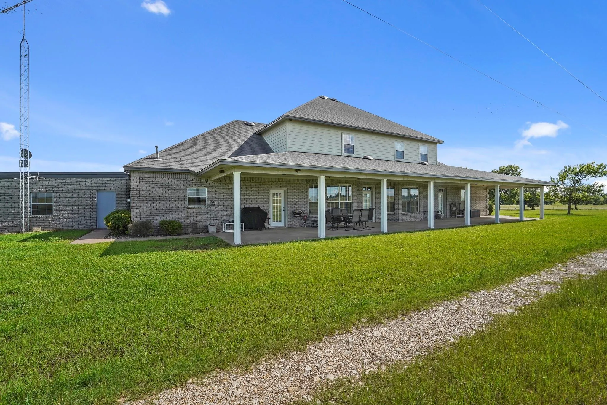 Back of house with a yard and a patio