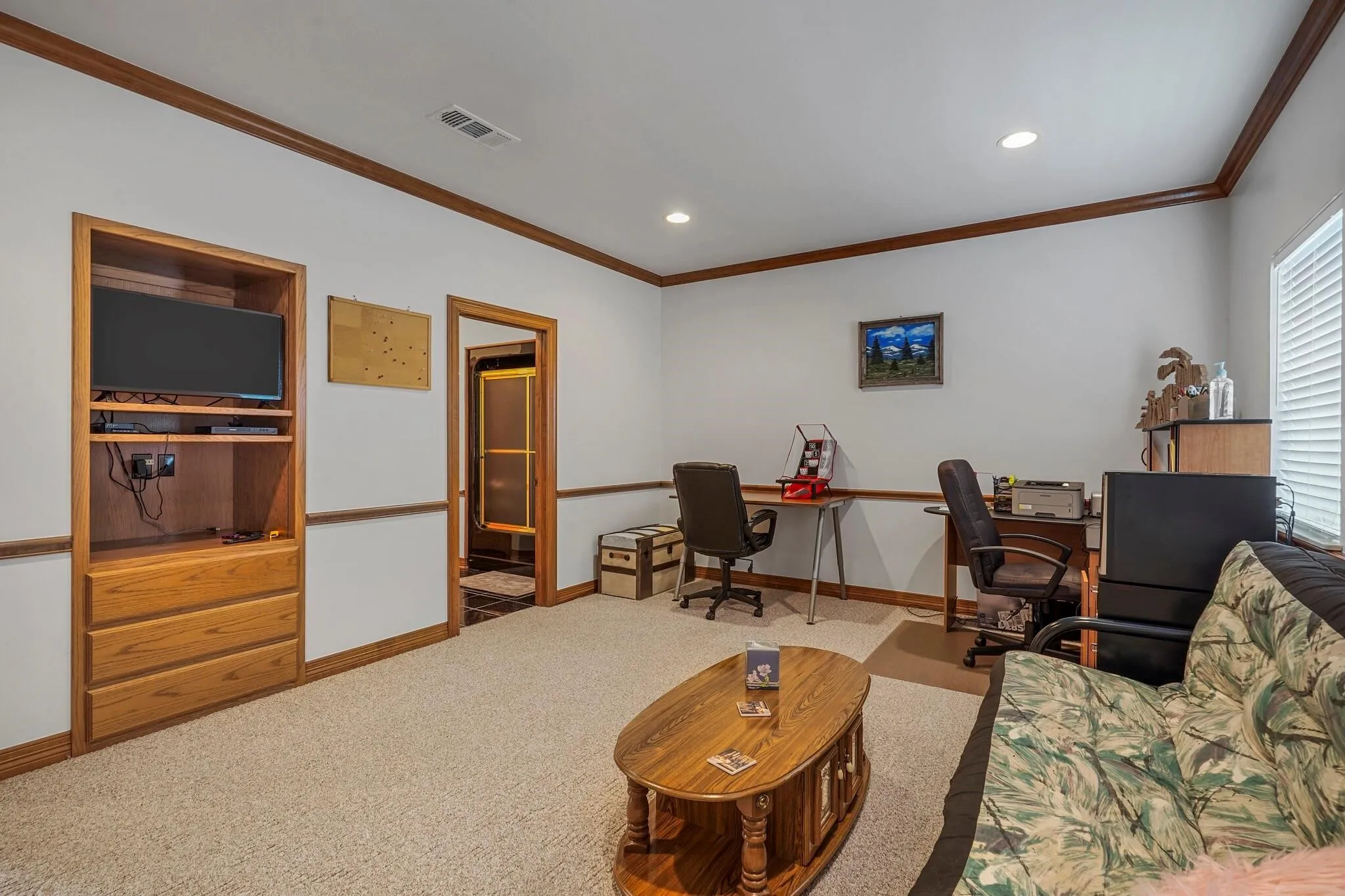 Carpeted living room featuring crown molding