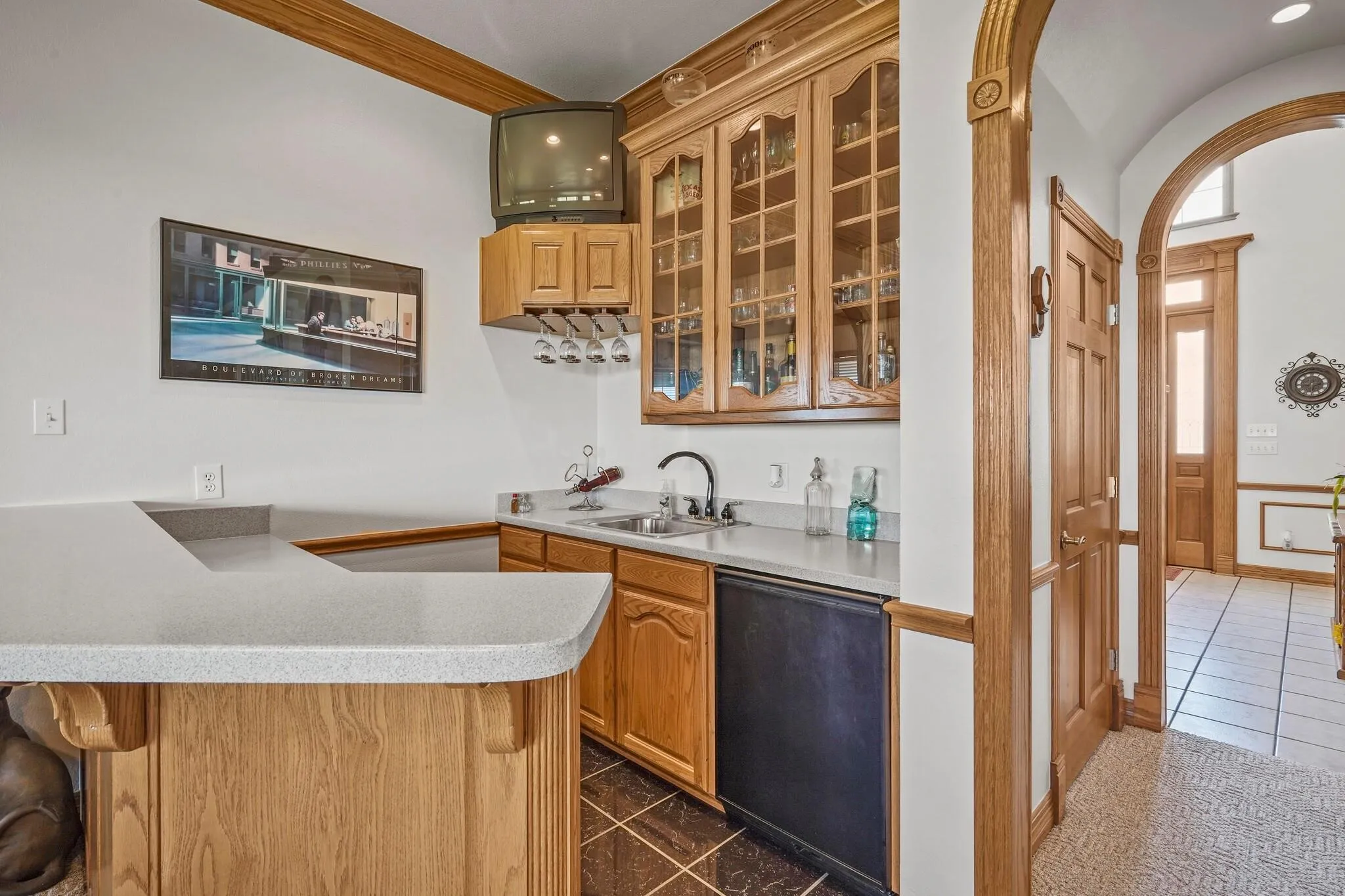 Kitchen featuring black dishwasher, crown molding, kitchen peninsula, and sink