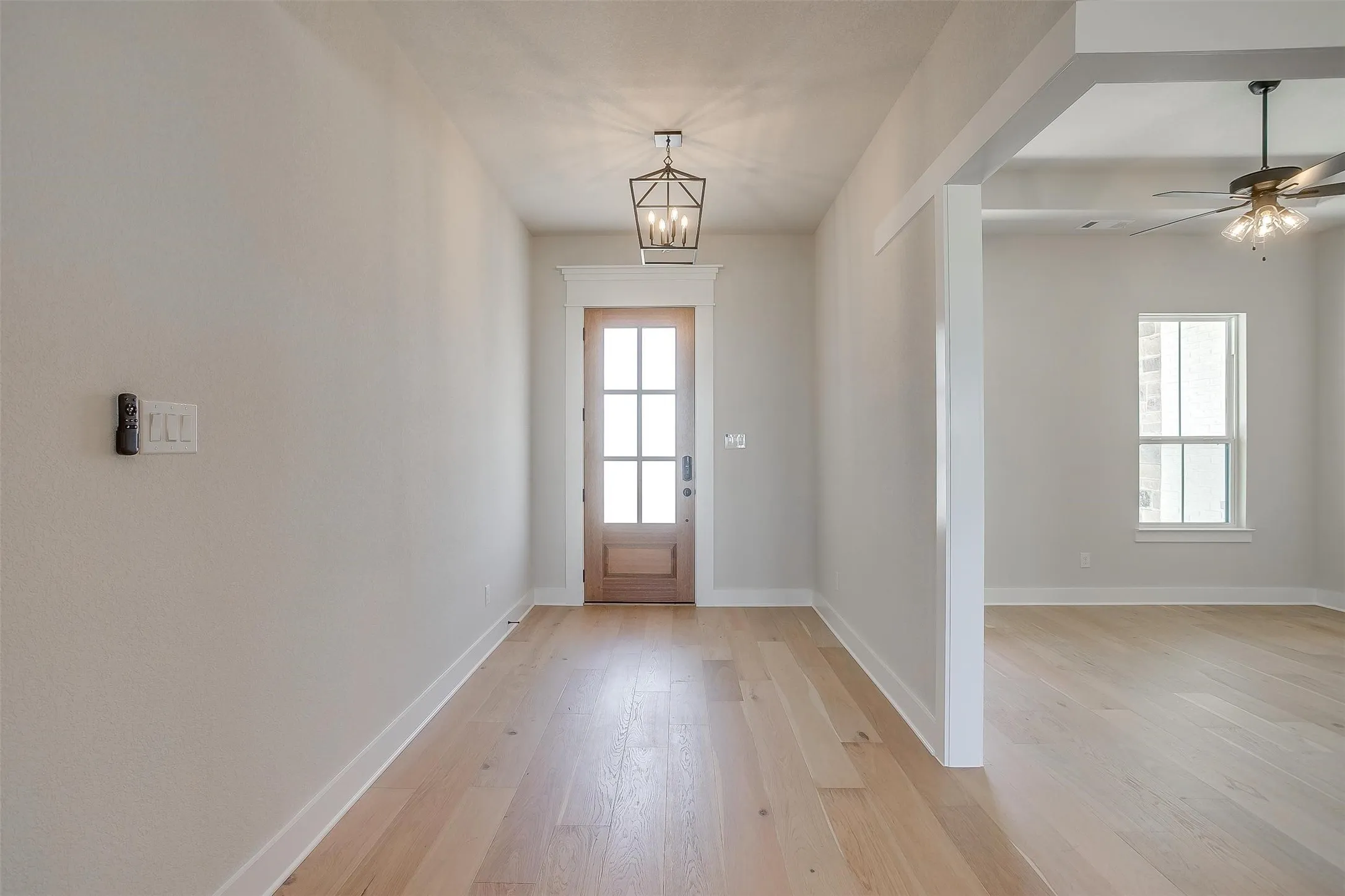 Doorway featuring baseboards, light wood-type flooring, and plenty of natural light