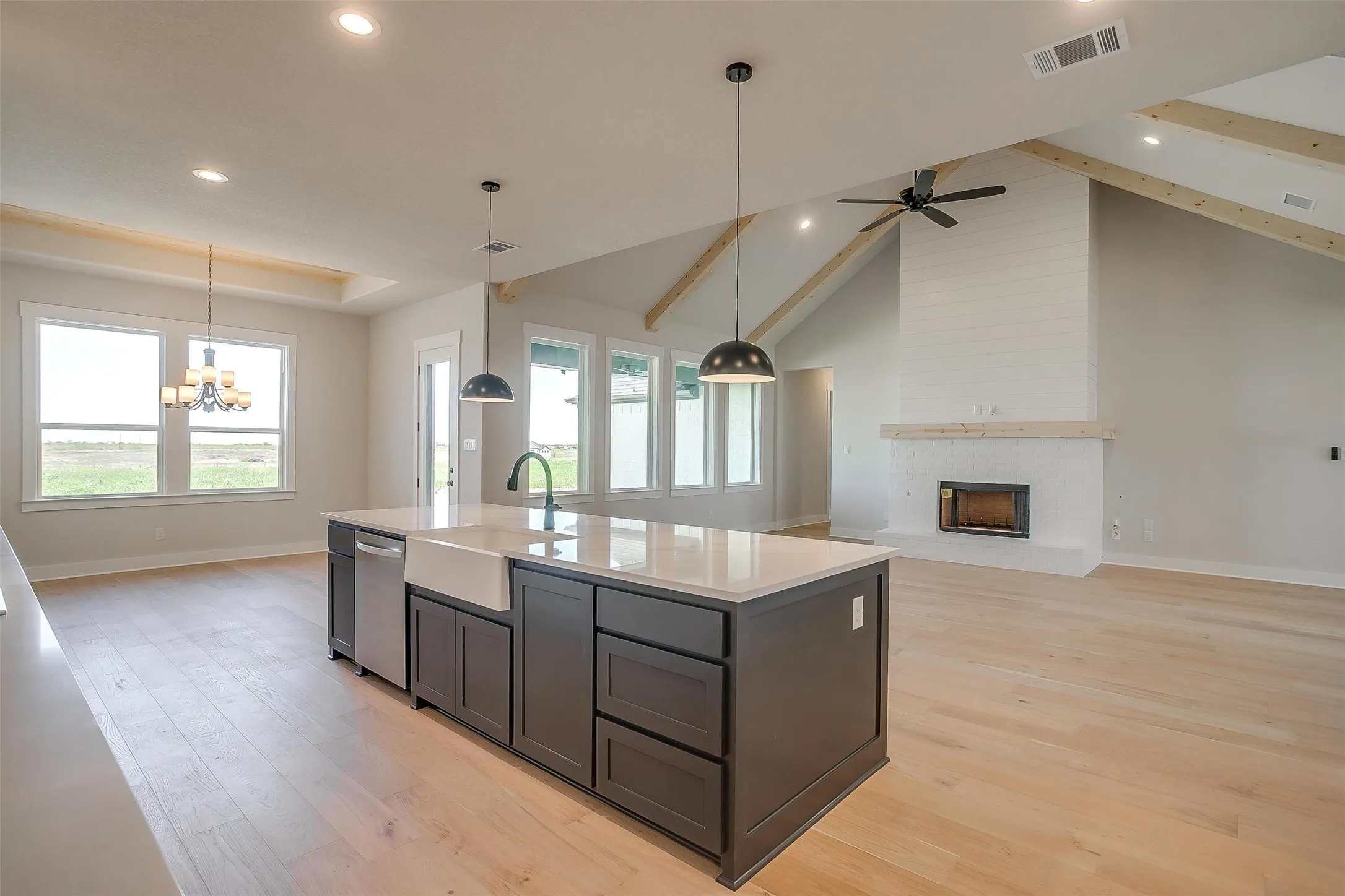 Kitchen with light wood-type flooring, plenty of natural light, visible vents, dishwasher, and a sink