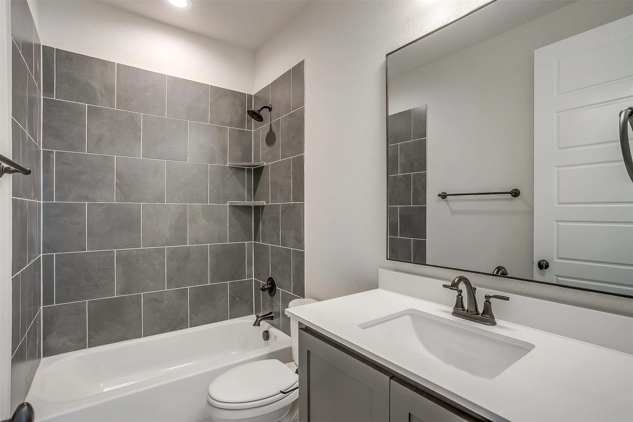 Bathroom featuring toilet, vanity, and  shower combination