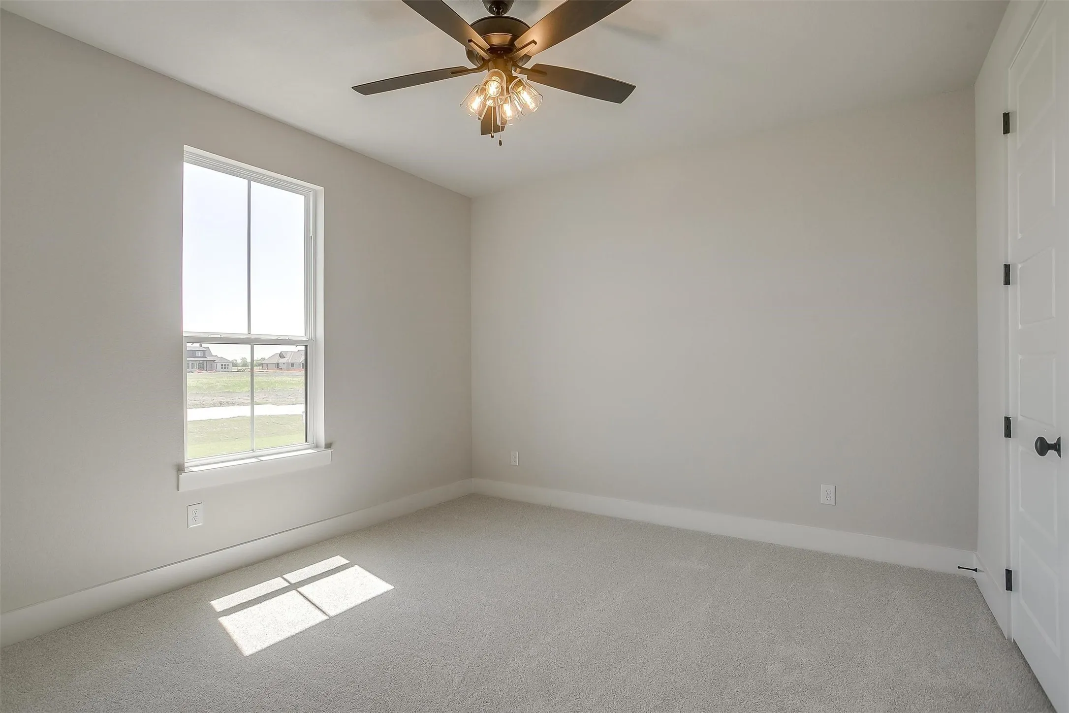 Carpeted spare room featuring baseboards and a ceiling fan
