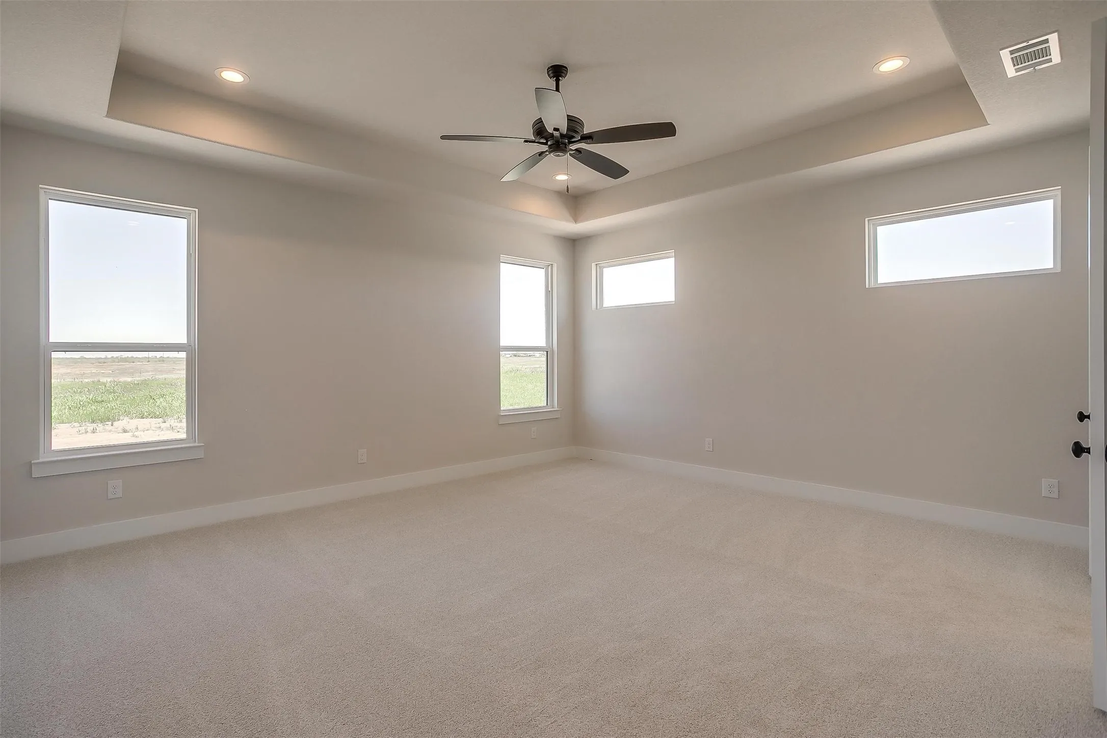 Spare room featuring visible vents, baseboards, and a raised ceiling