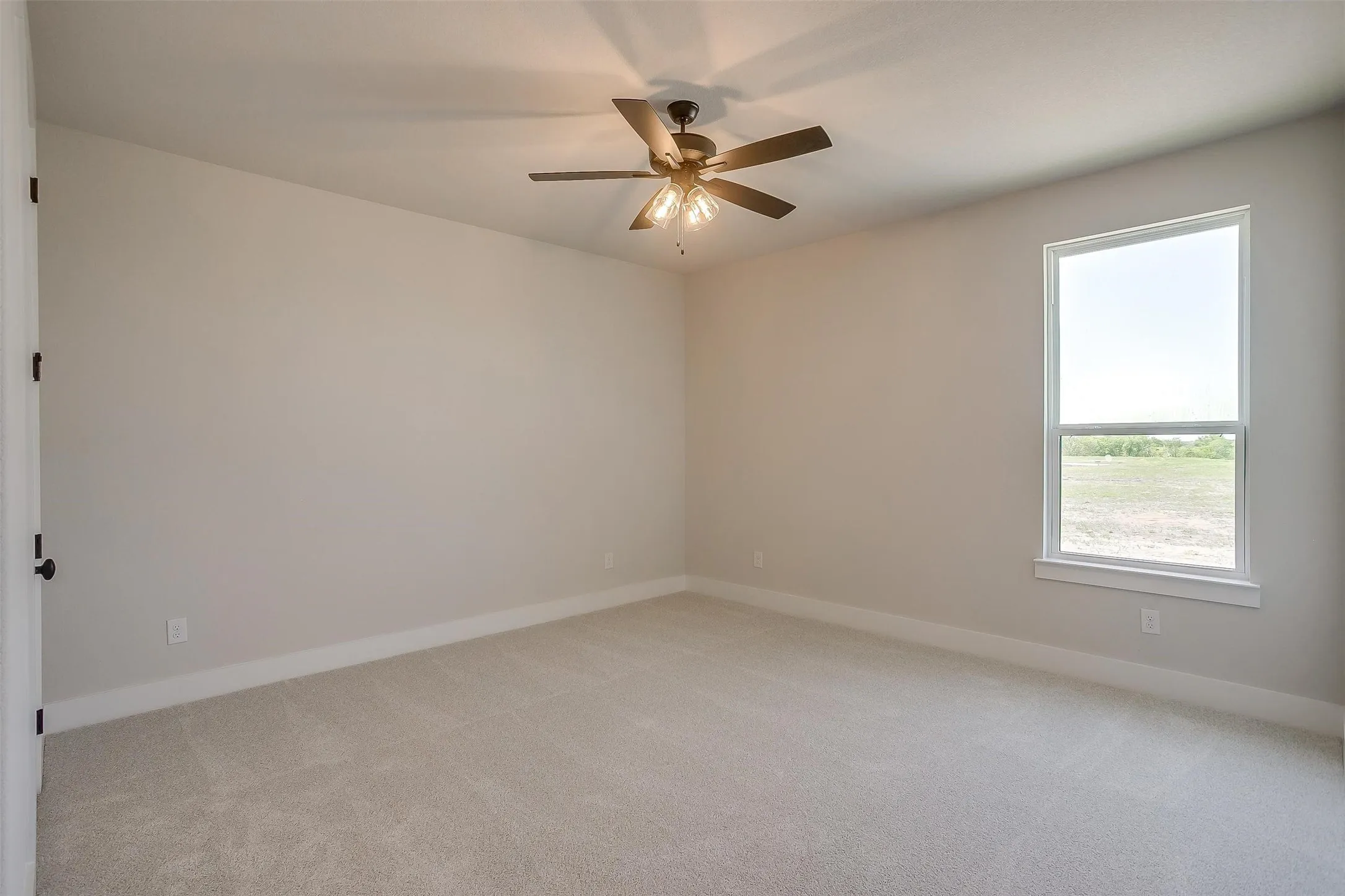 Unfurnished room with light colored carpet, ceiling fan, and baseboards