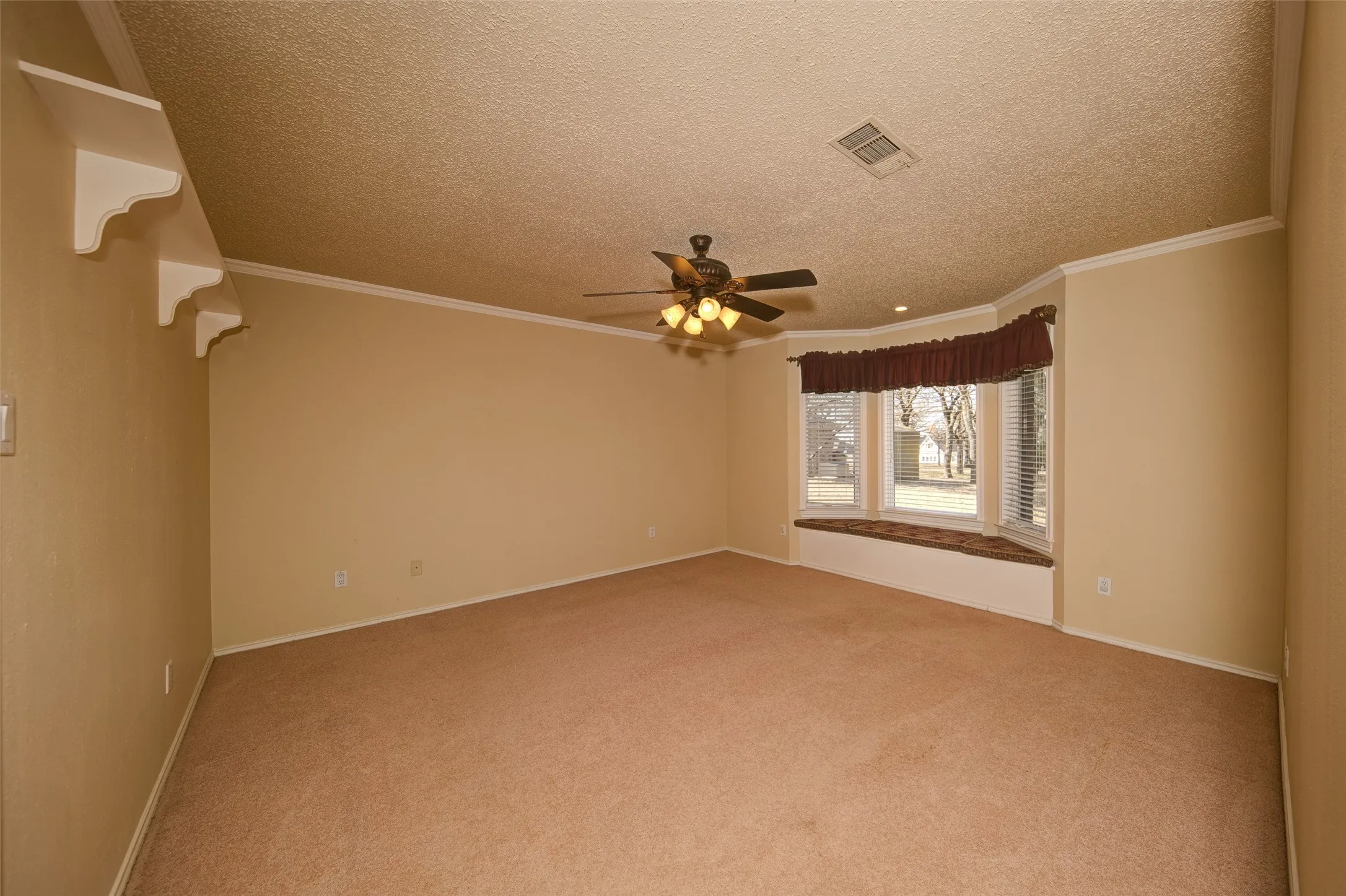 Unfurnished room with carpet floors, ceiling fan, a textured ceiling, and ornamental molding