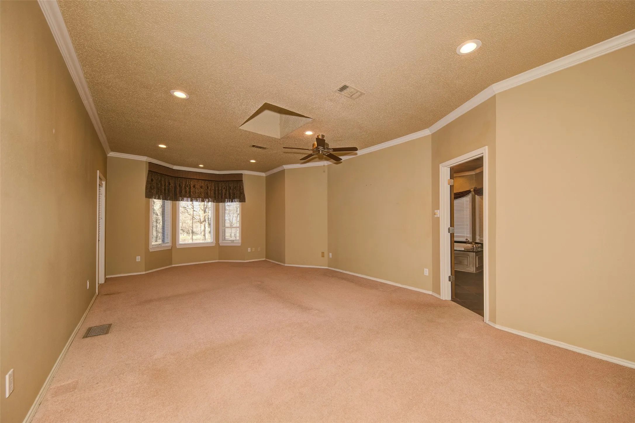 Unfurnished room with a textured ceiling, carpet, recessed lighting, a ceiling fan, and crown molding