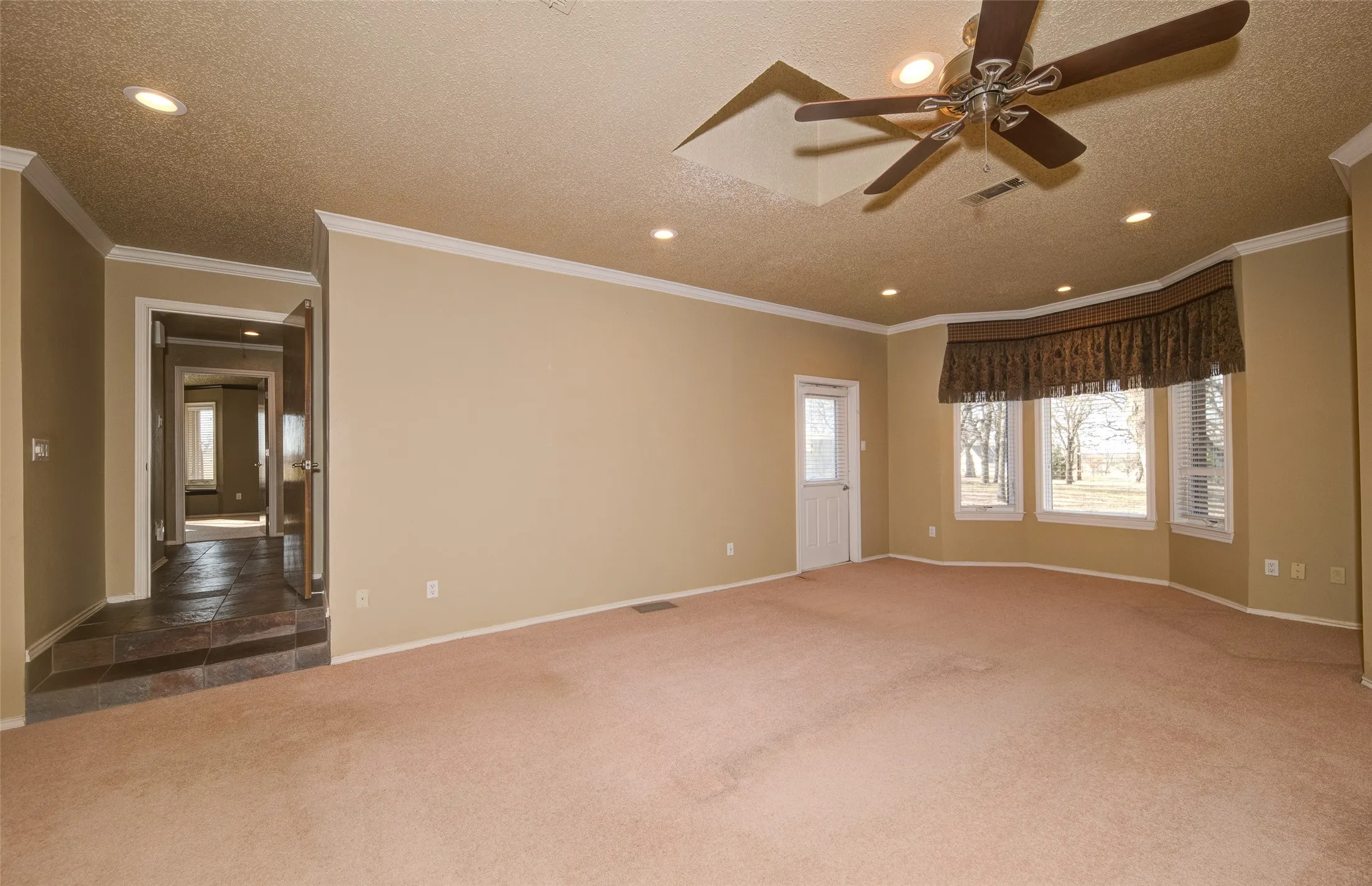 Carpeted empty room with ceiling fan, recessed lighting, a textured ceiling, and crown molding
