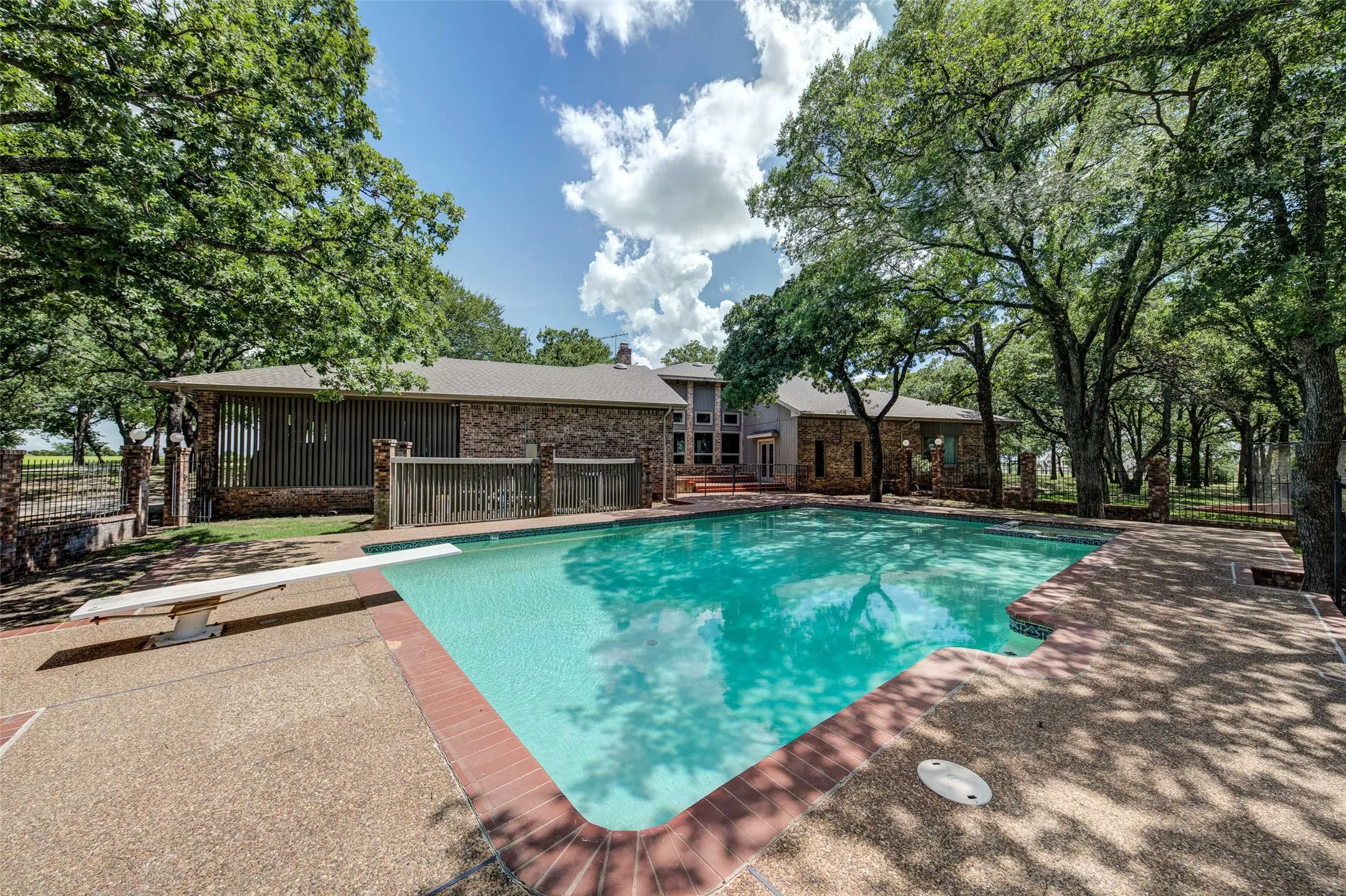 View of pool with a diving board and a patio area
