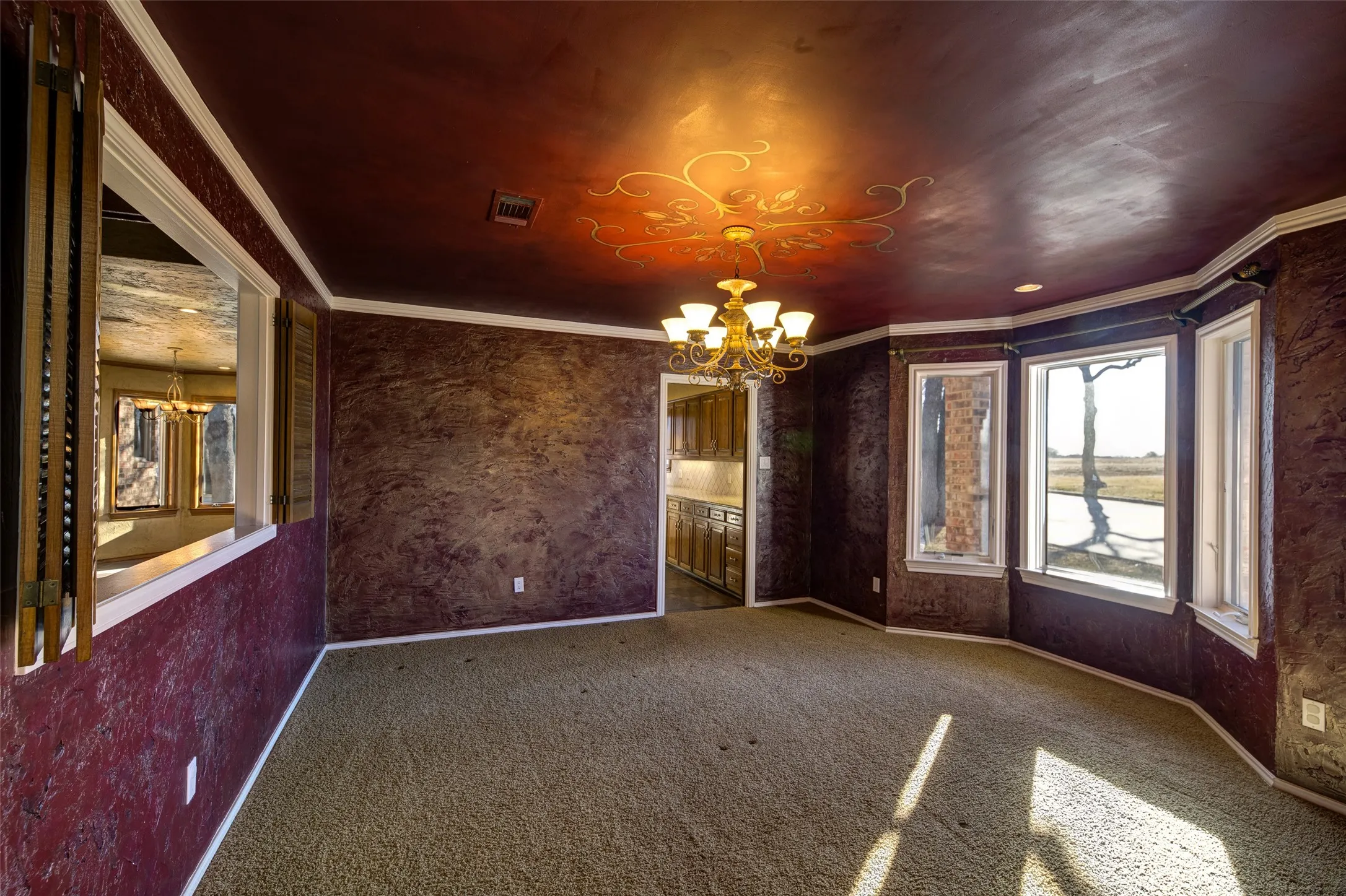 Unfurnished room featuring a chandelier, ornamental molding, and carpet