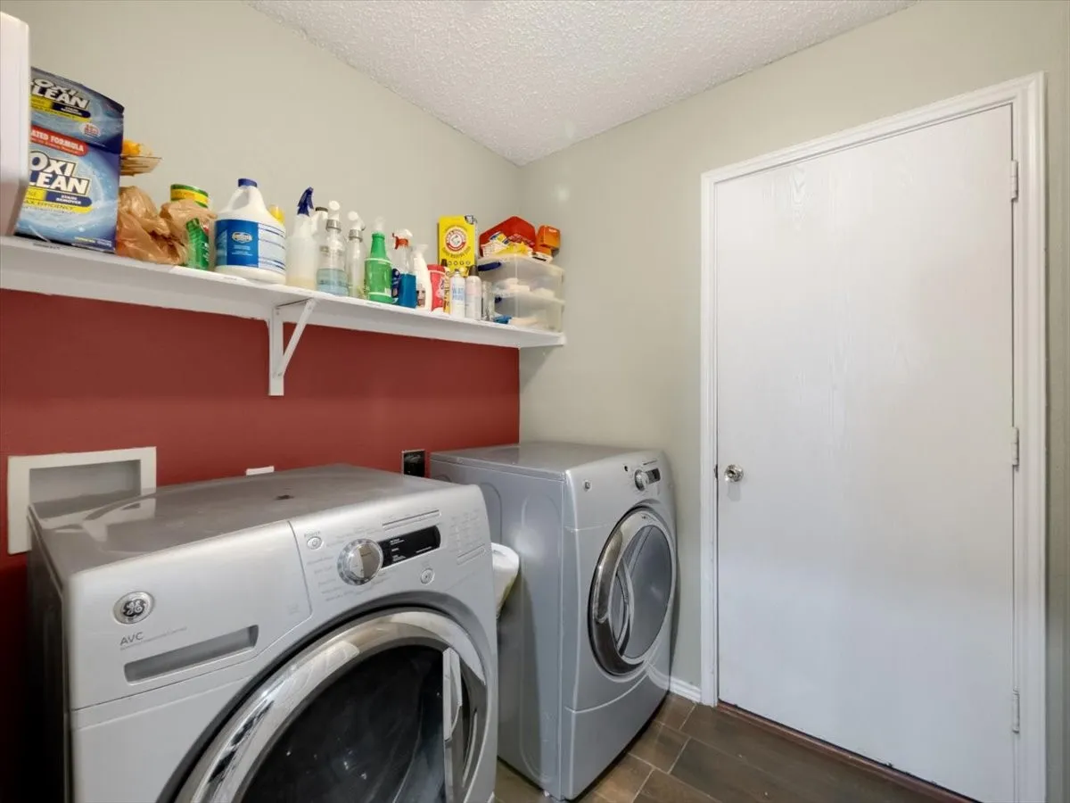 Washroom with a textured ceiling and washer and dryer