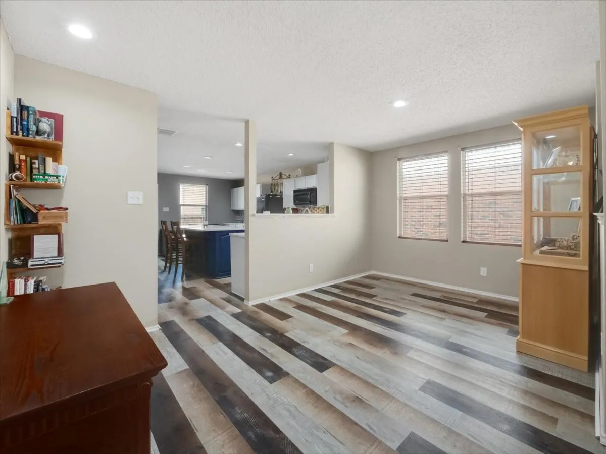 Living room with a textured ceiling and hardwood / wood-style floors