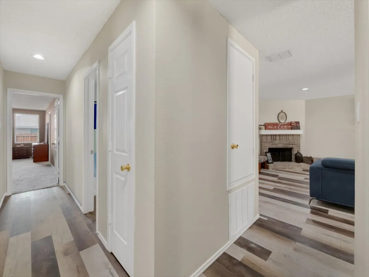 Hall featuring a textured ceiling and light hardwood / wood-style flooring