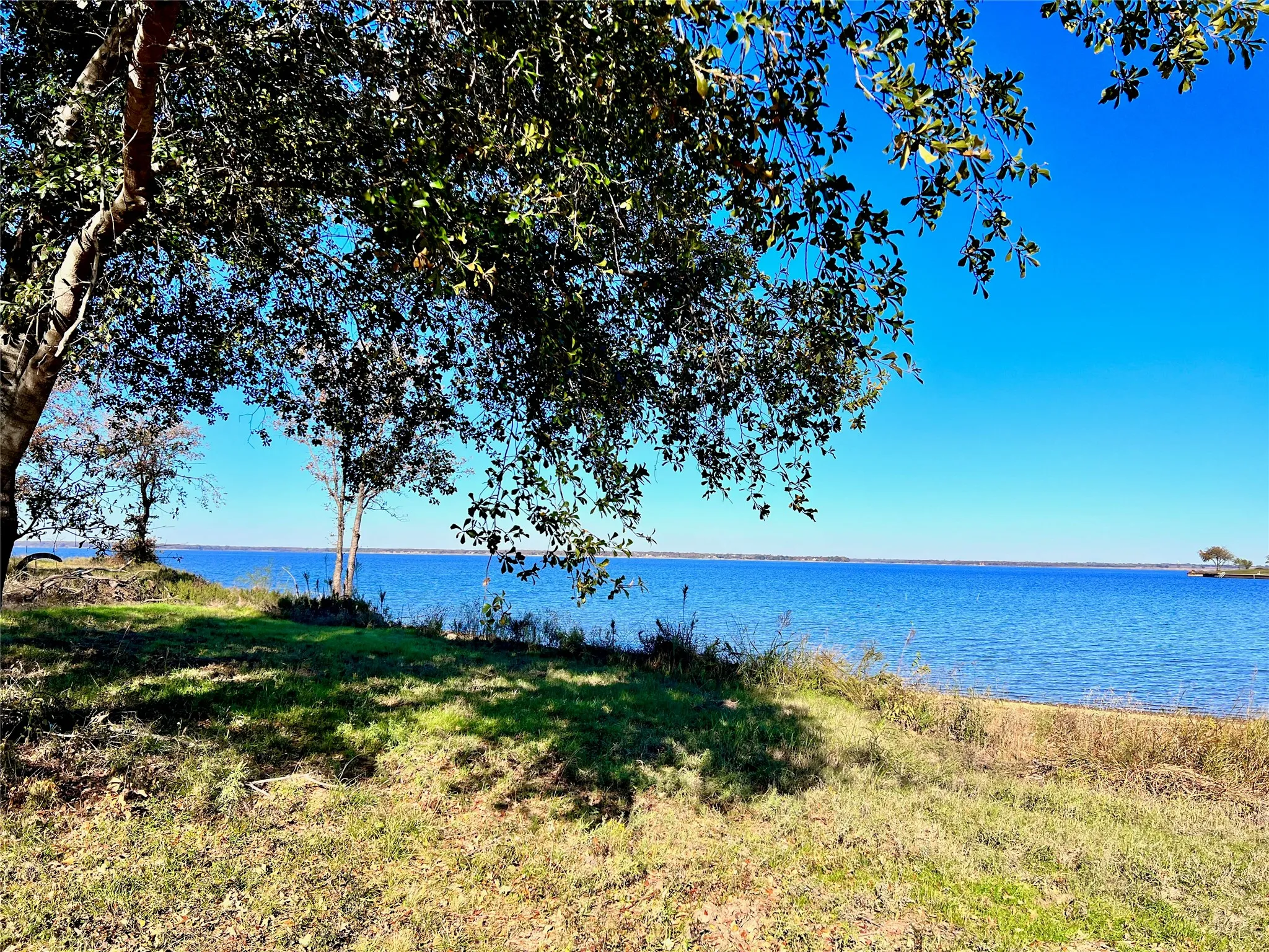Mature shade trees frame beautiful open water views.