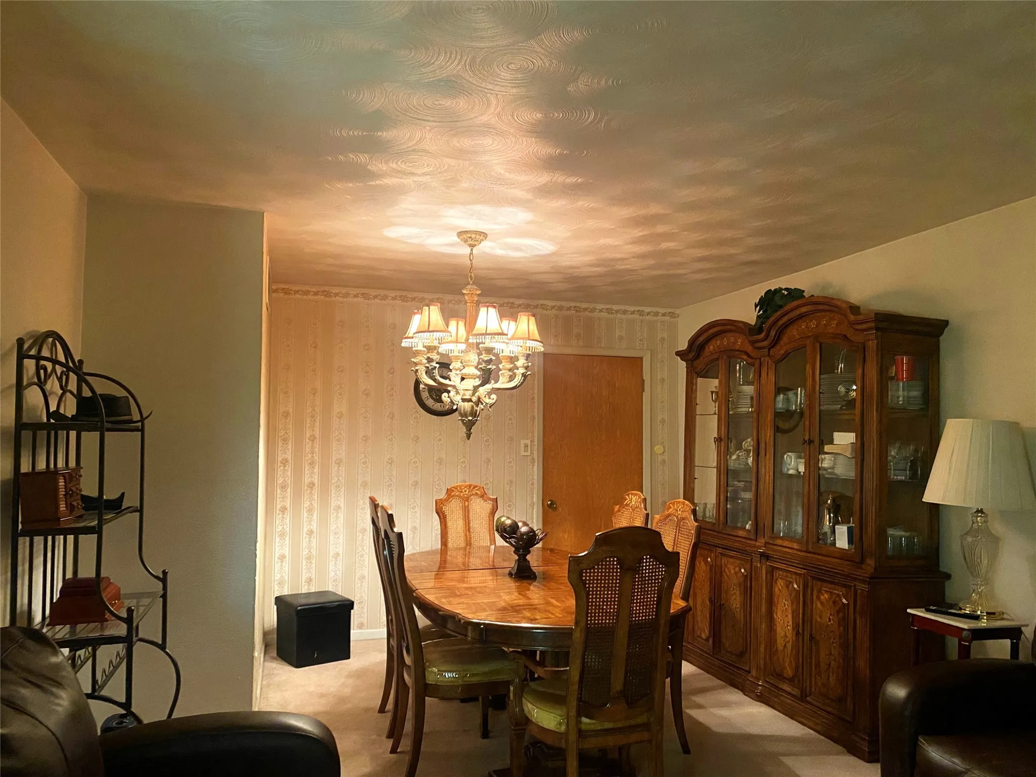 Carpeted dining area with an inviting chandelier