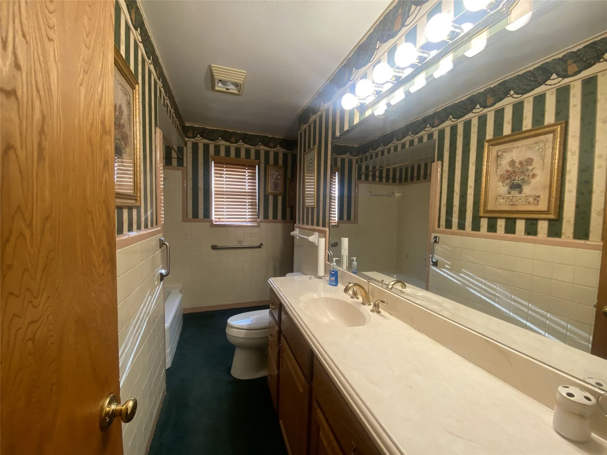 Bathroom with toilet, tile walls, and vanity