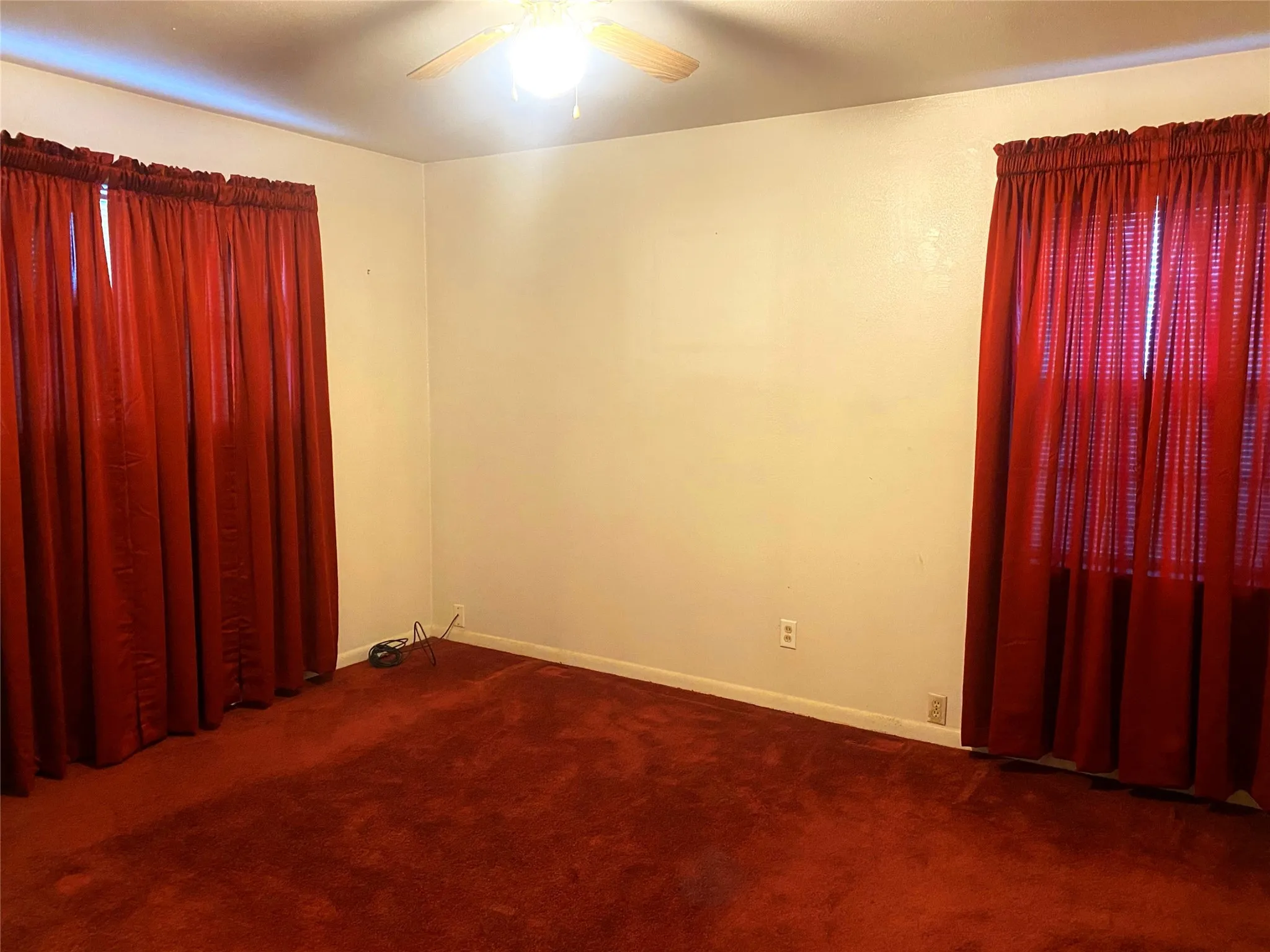 Carpeted spare room with ceiling fan
